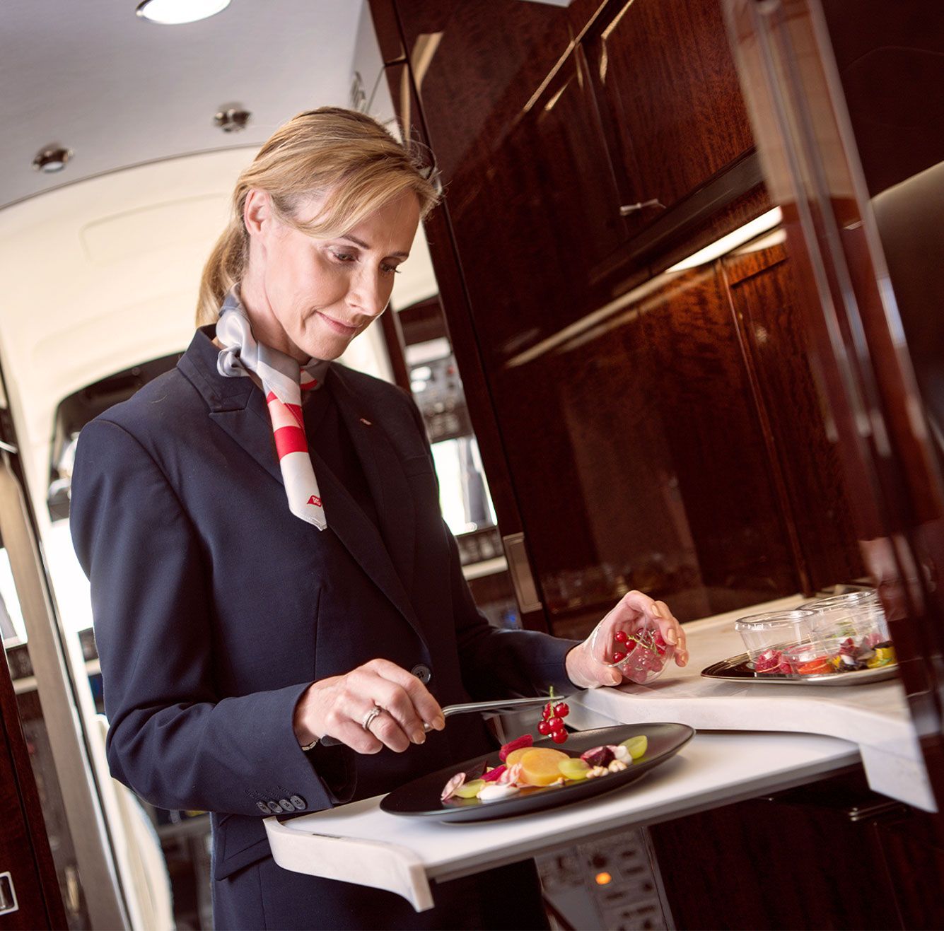 A Flight Attendant prepares food onboard a private jet.