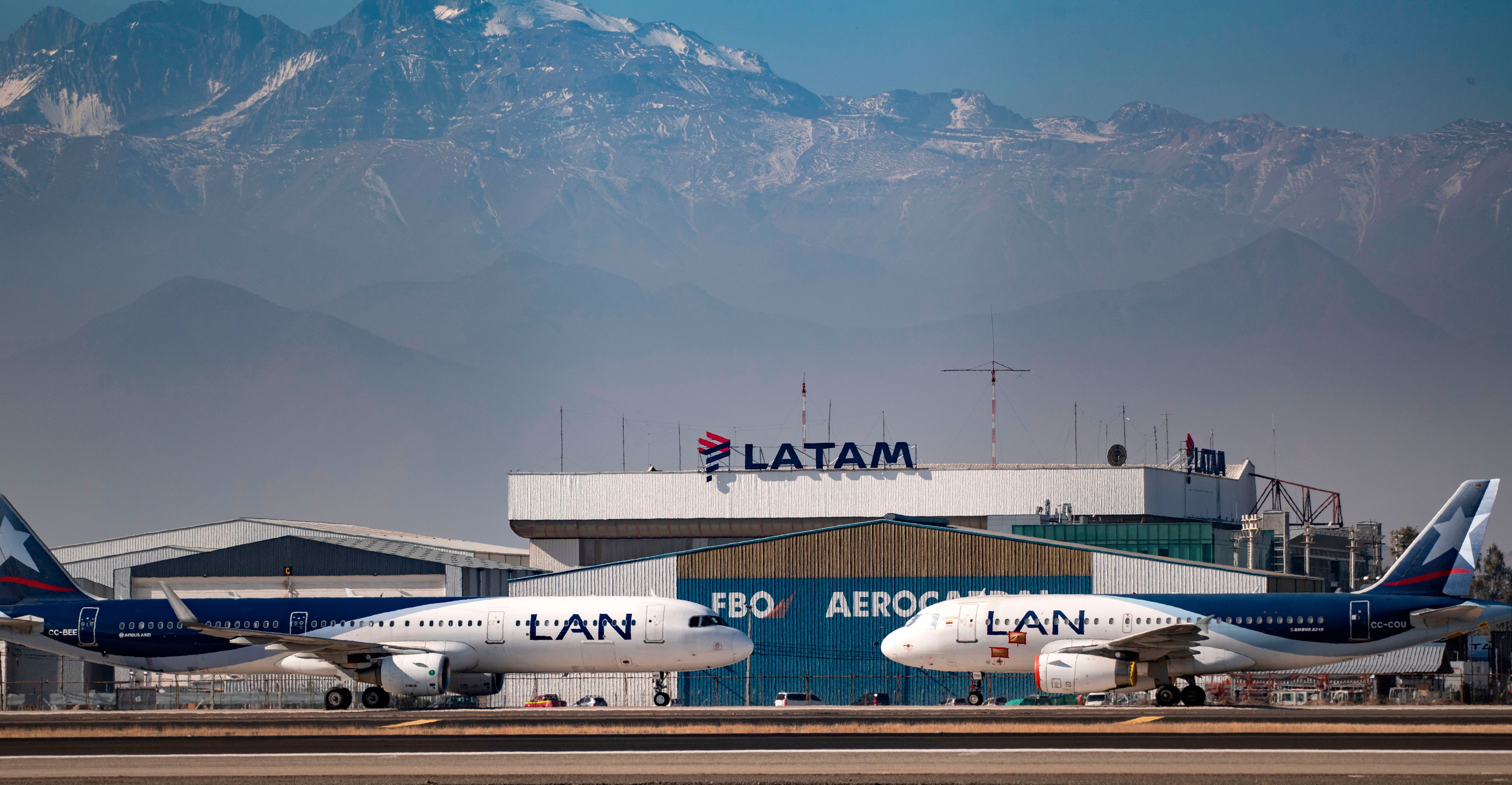 Two LATAM aircraft in front of a LATAM hangar.