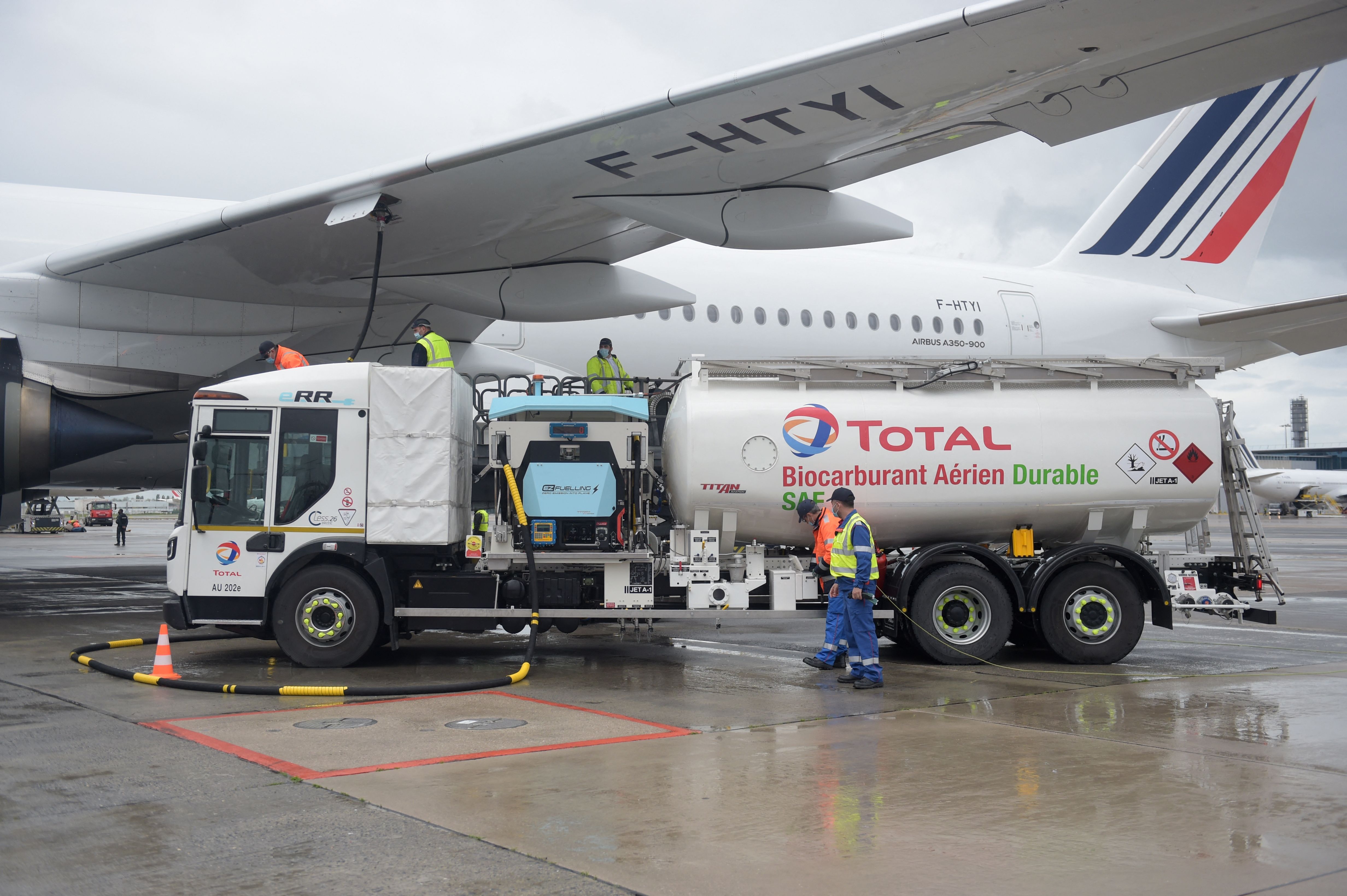 Staff members refuel an Airbus A350-900 with SAF