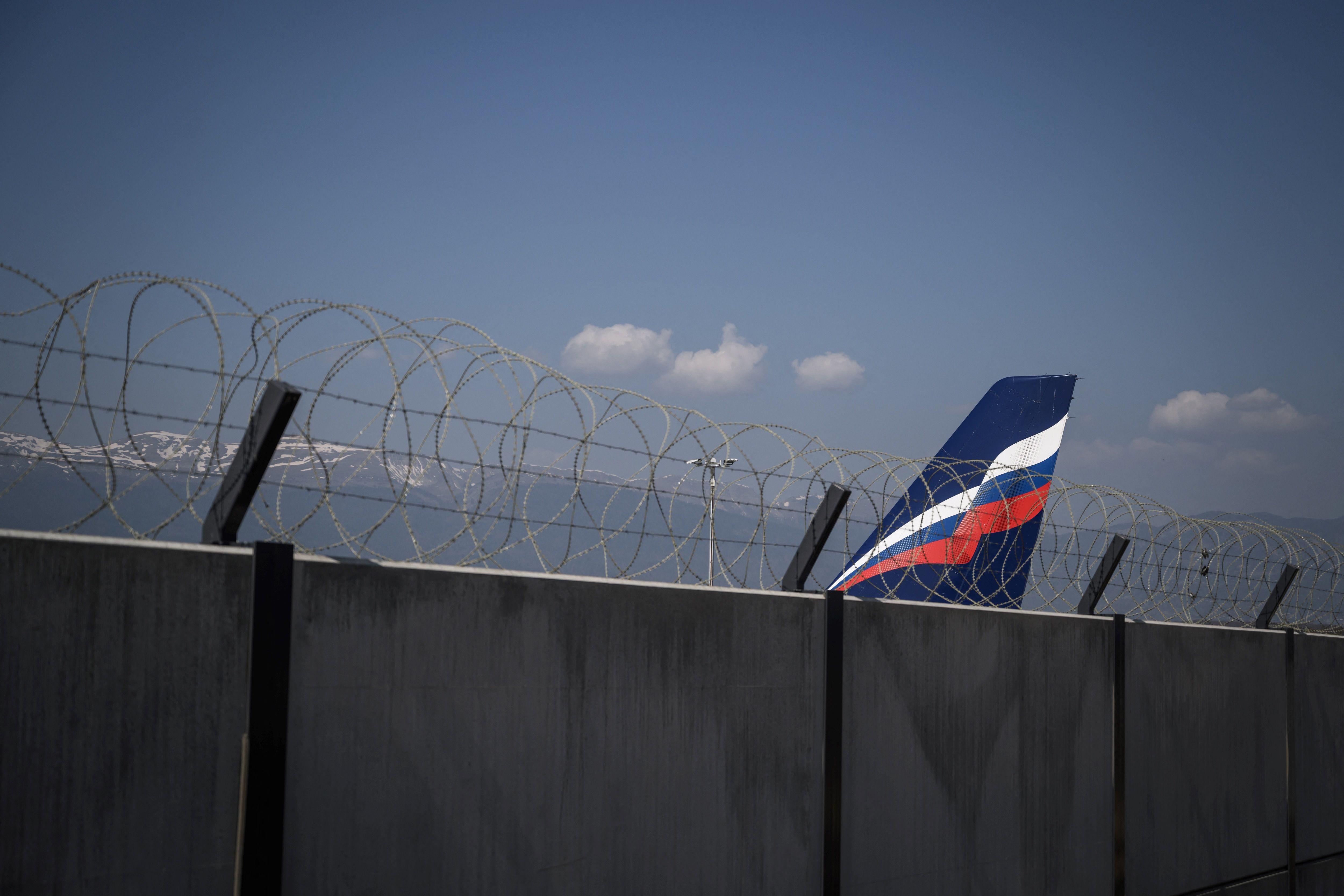The tail of an Airbus A321-211 aircraft of Russian airline Aeroflot with registration VP-BOE is seen over the wall of the long term parking for planes of Geneva Airport on March 25, 2022.