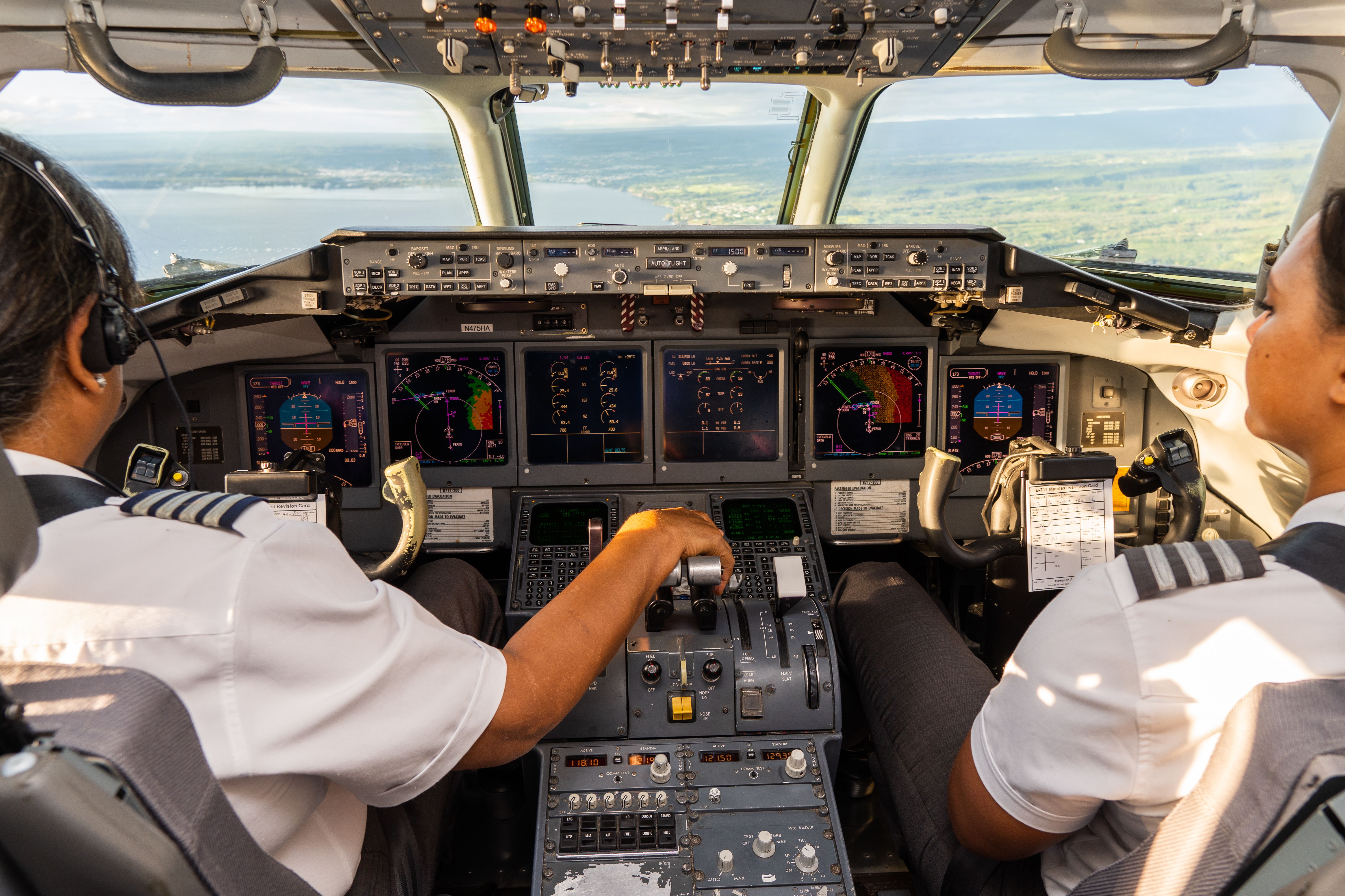 View from inside a Hawaiian Airlines cockpit, as two pilots are flying the aircraft.