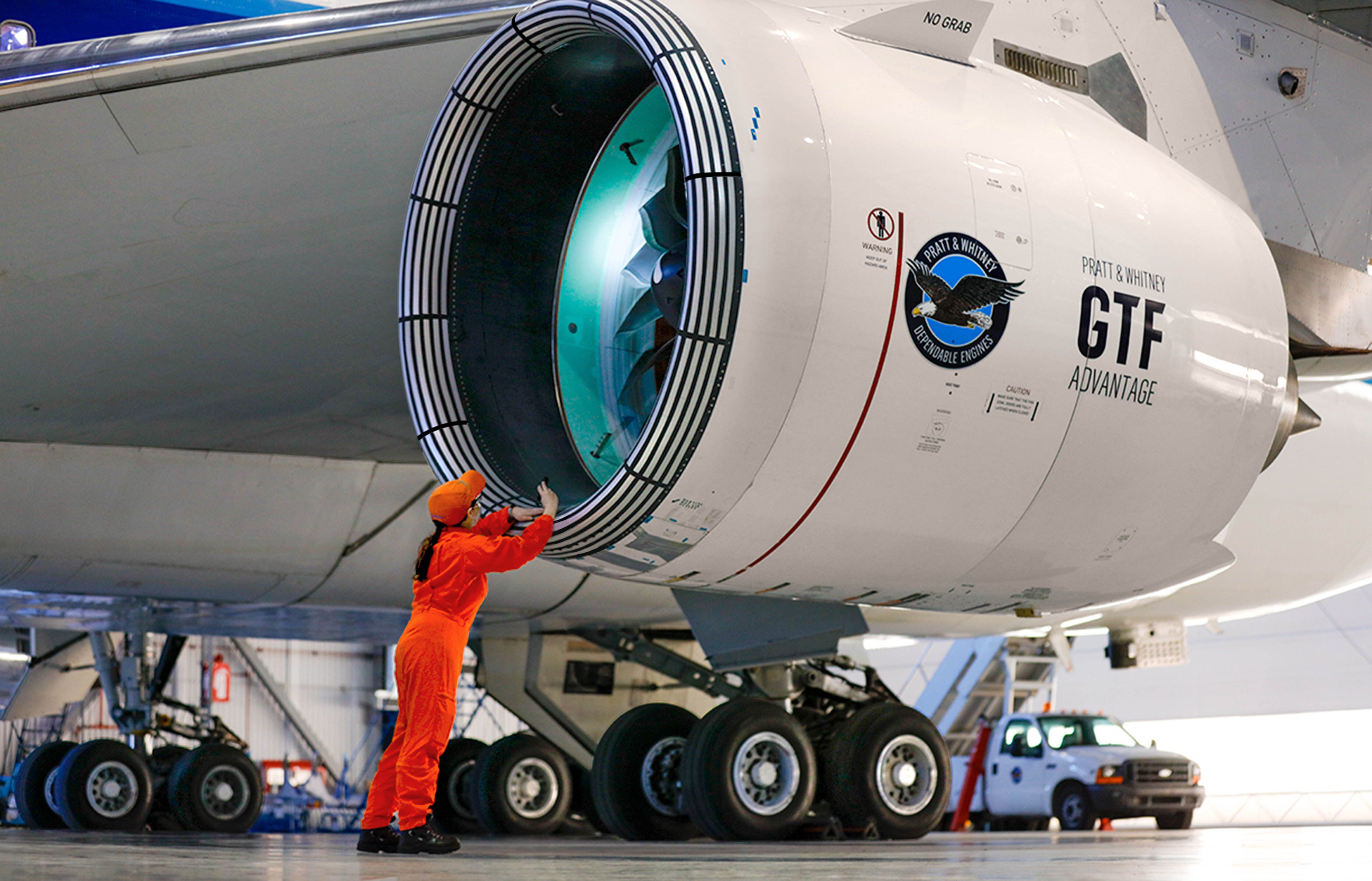 A Pratt & Whitney GTF Advantage engine being checked in an aircraft hangar.