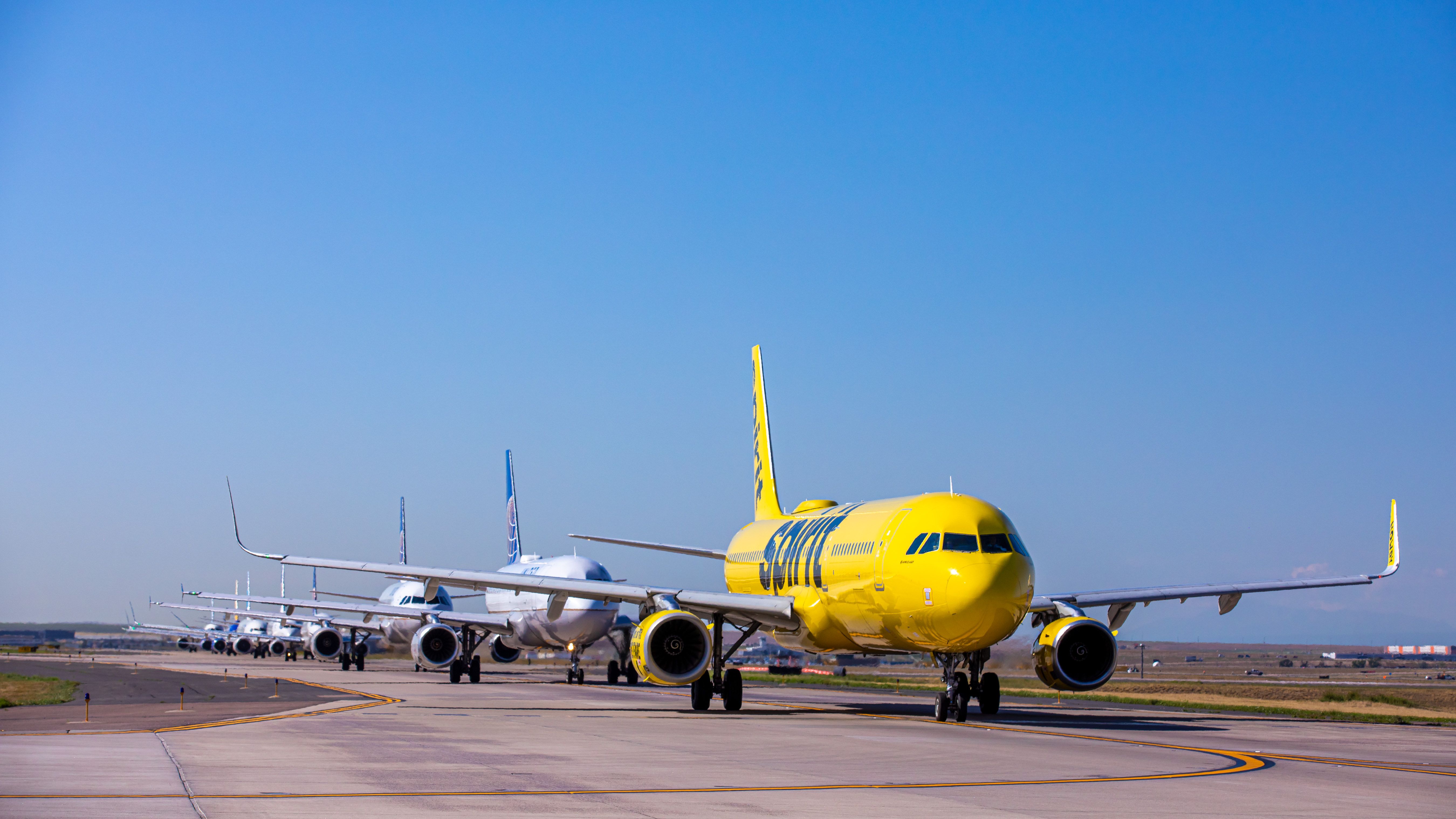 Spirit Airlines lineup at airport in front of United Airplanes