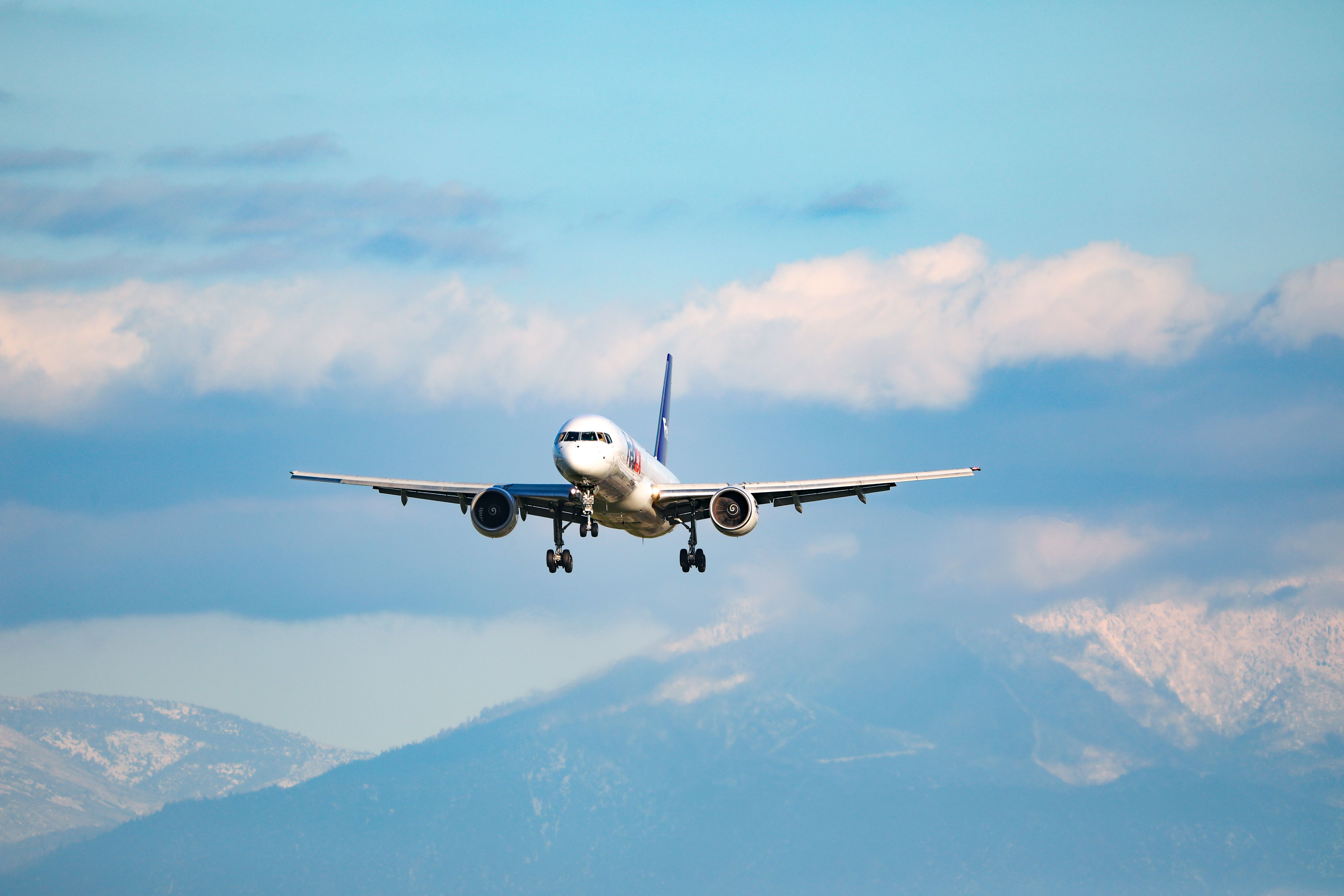 An aircraft coming in for a landing with mountains in the background.