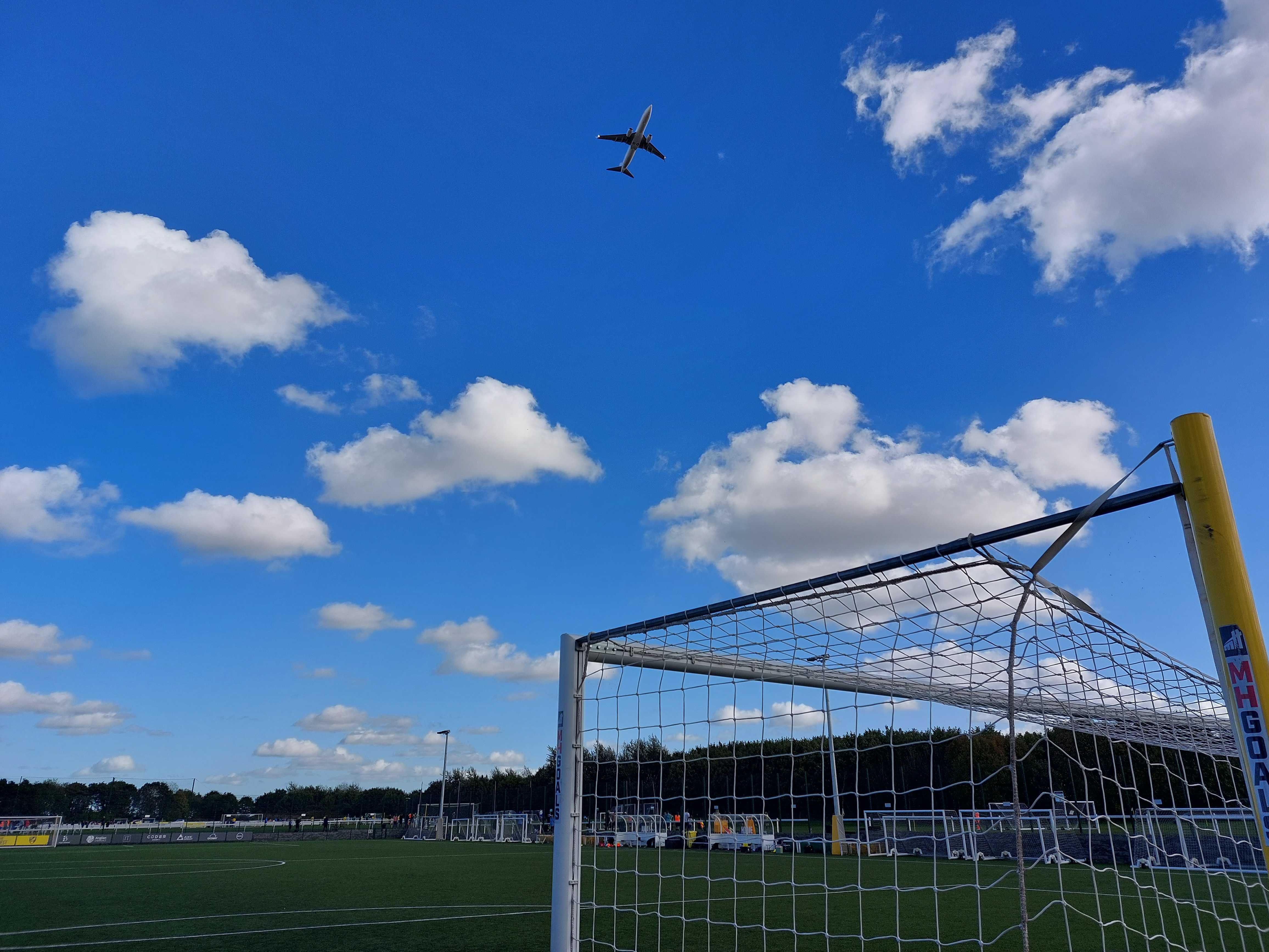 A plane flying over a football goal