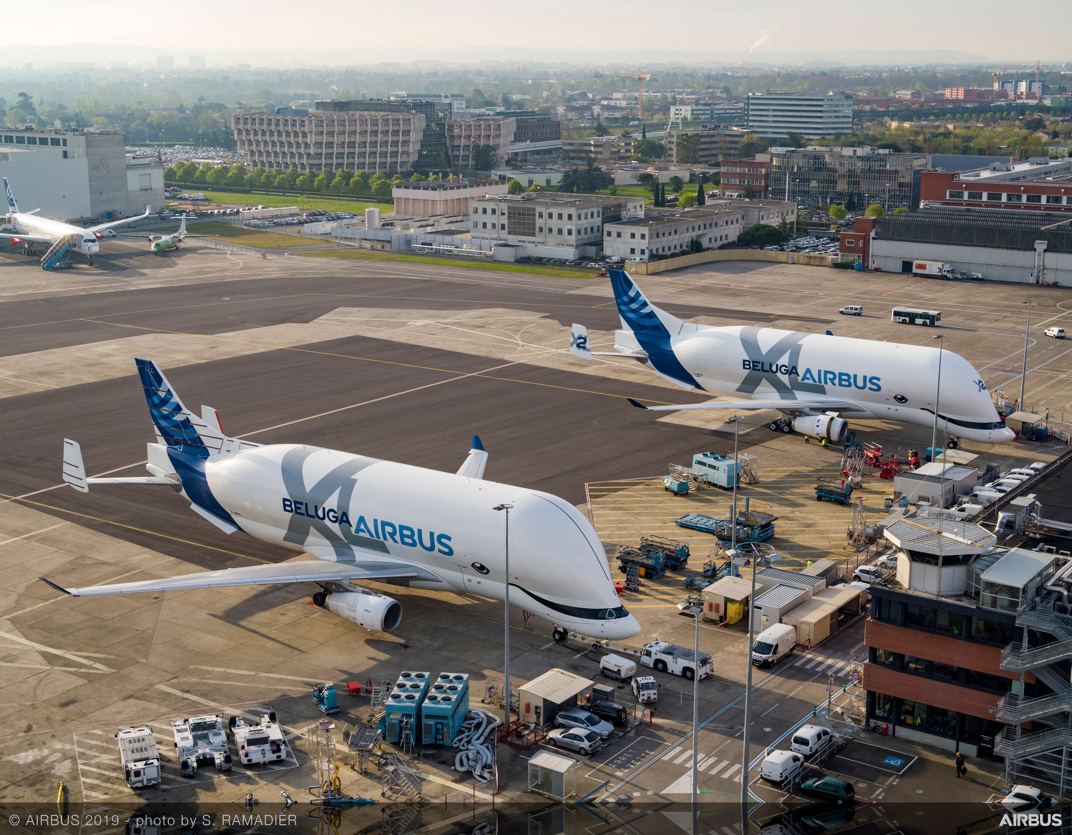 Two Airbus BelugaXL airlifters parked at an airport.