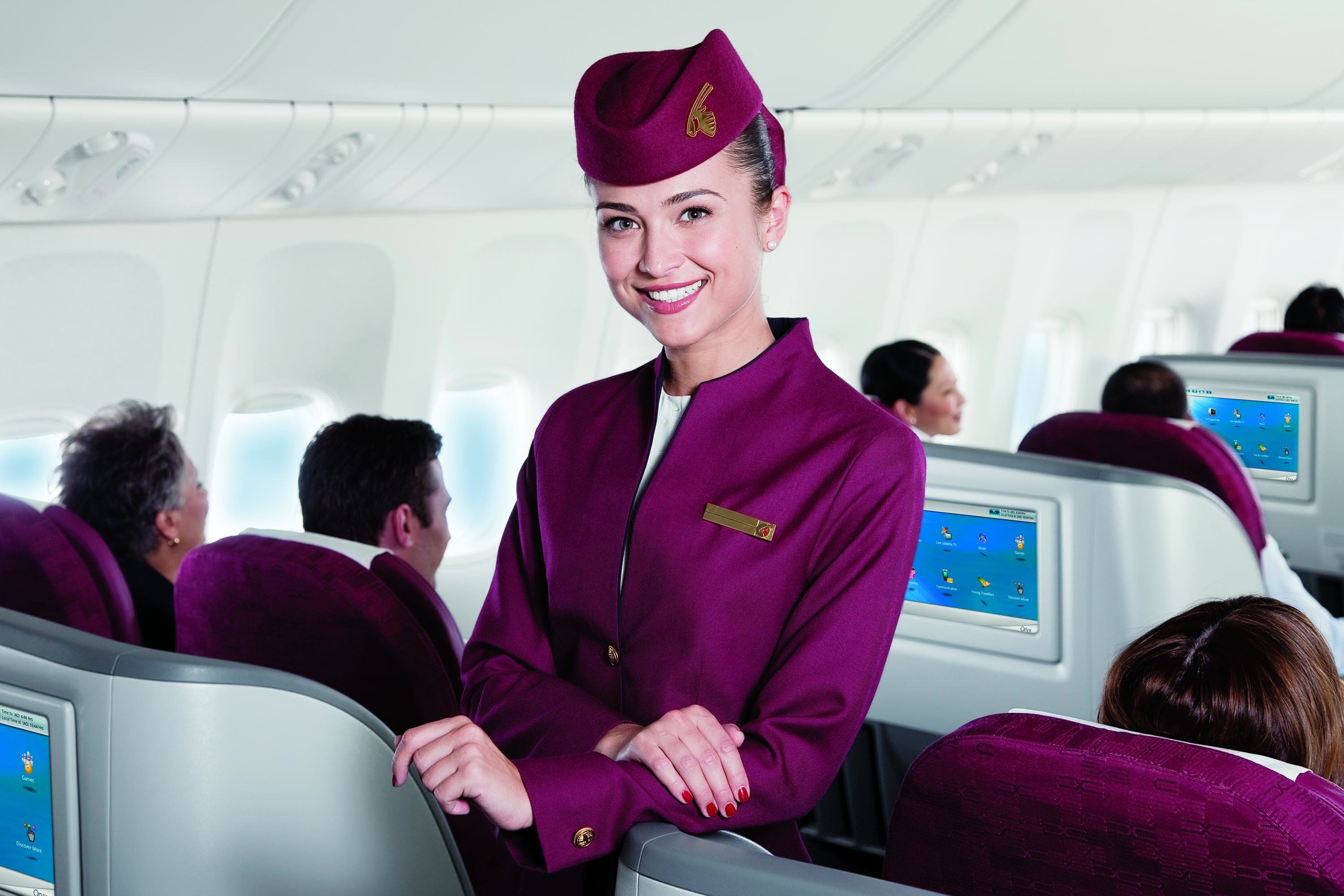A Qatar Airways cabin crew working in the business class cabin.