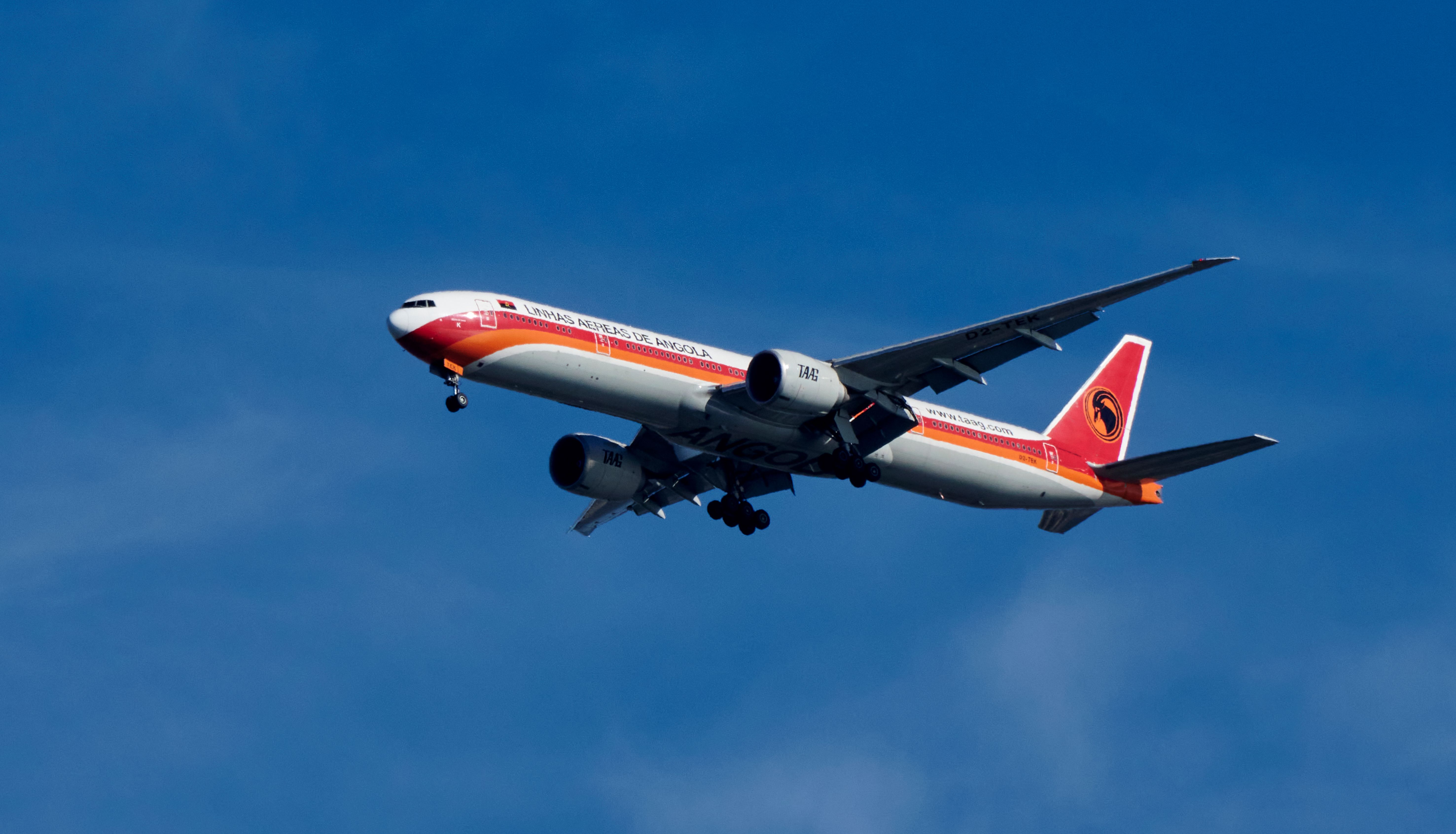 TAAG Angola Airlines Boeing 777 aircraft flies over the Tagus River 