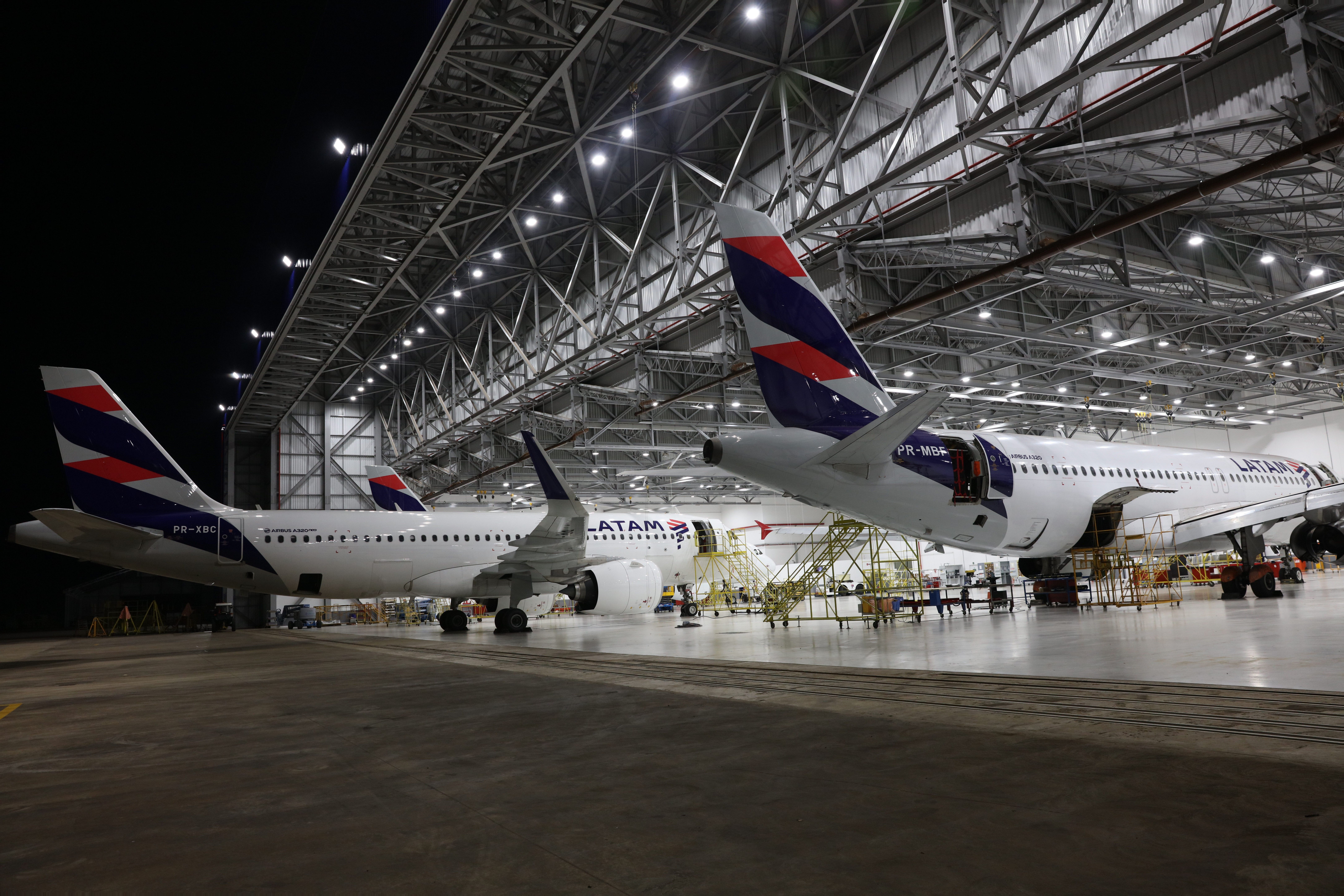 Two LATAM aircraft inside an MRO facility being maintained.
