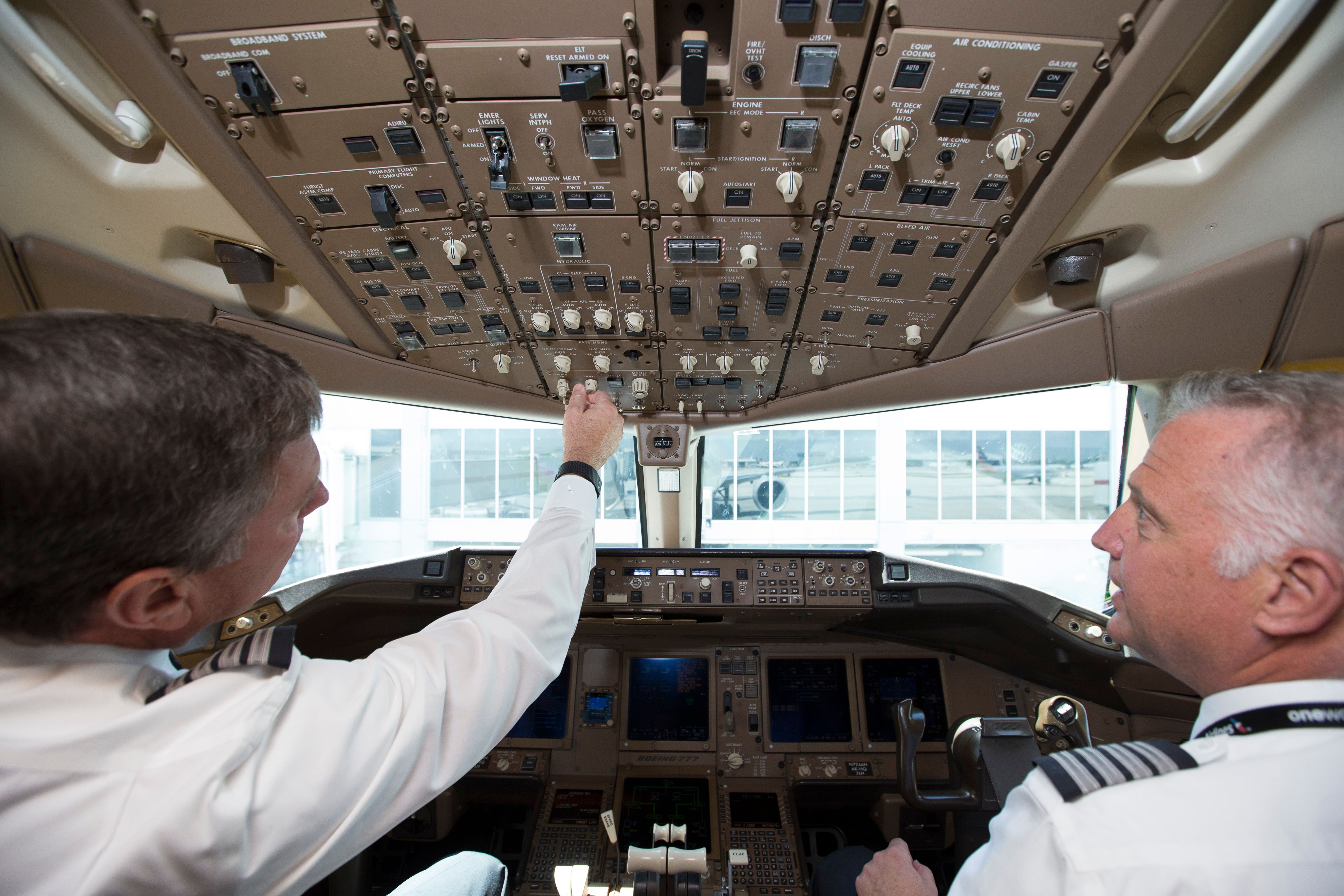 Two pilots preparing for a flight in the cockpit.