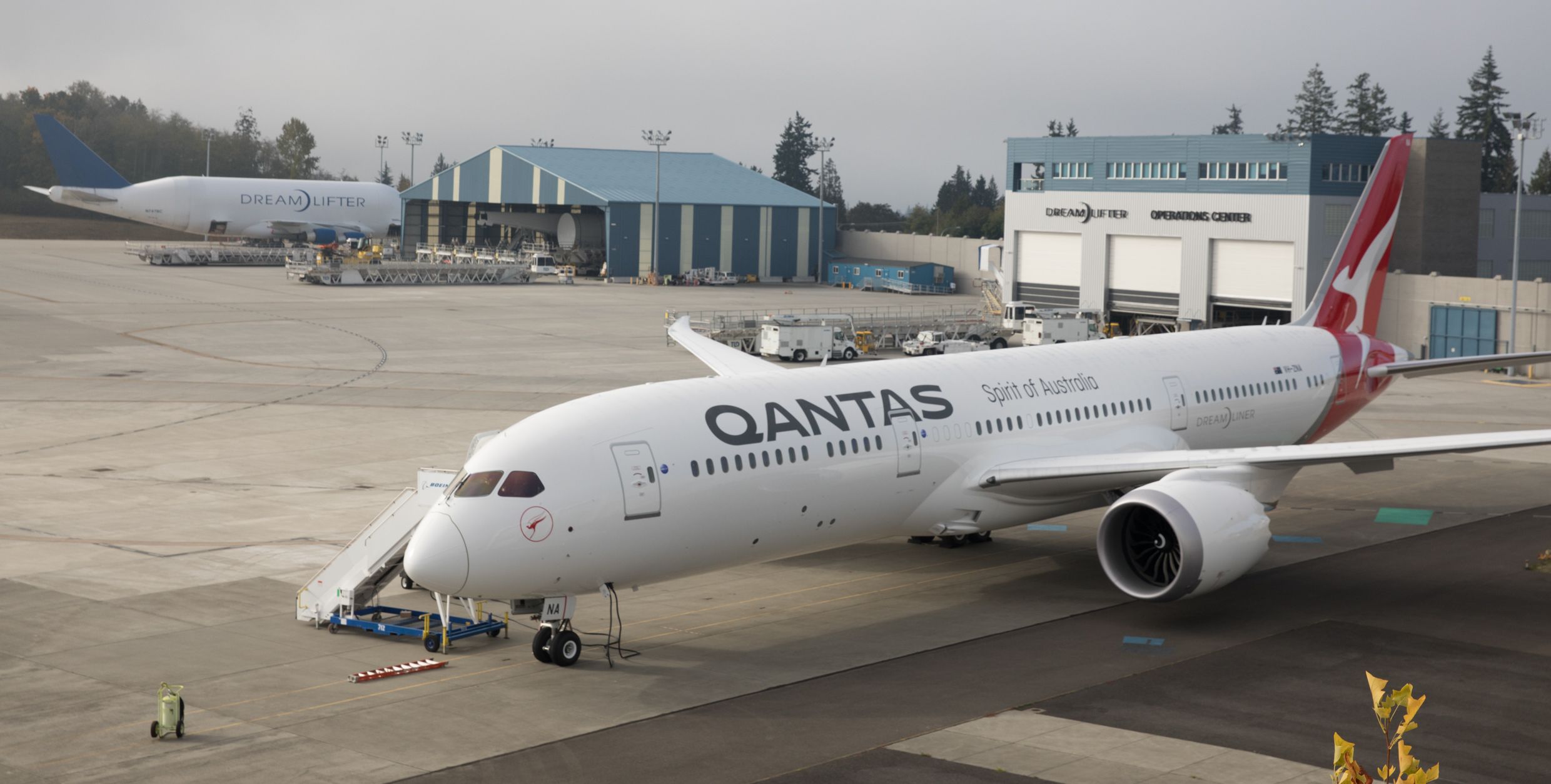 A Qantas aircraft parked near a hangar
