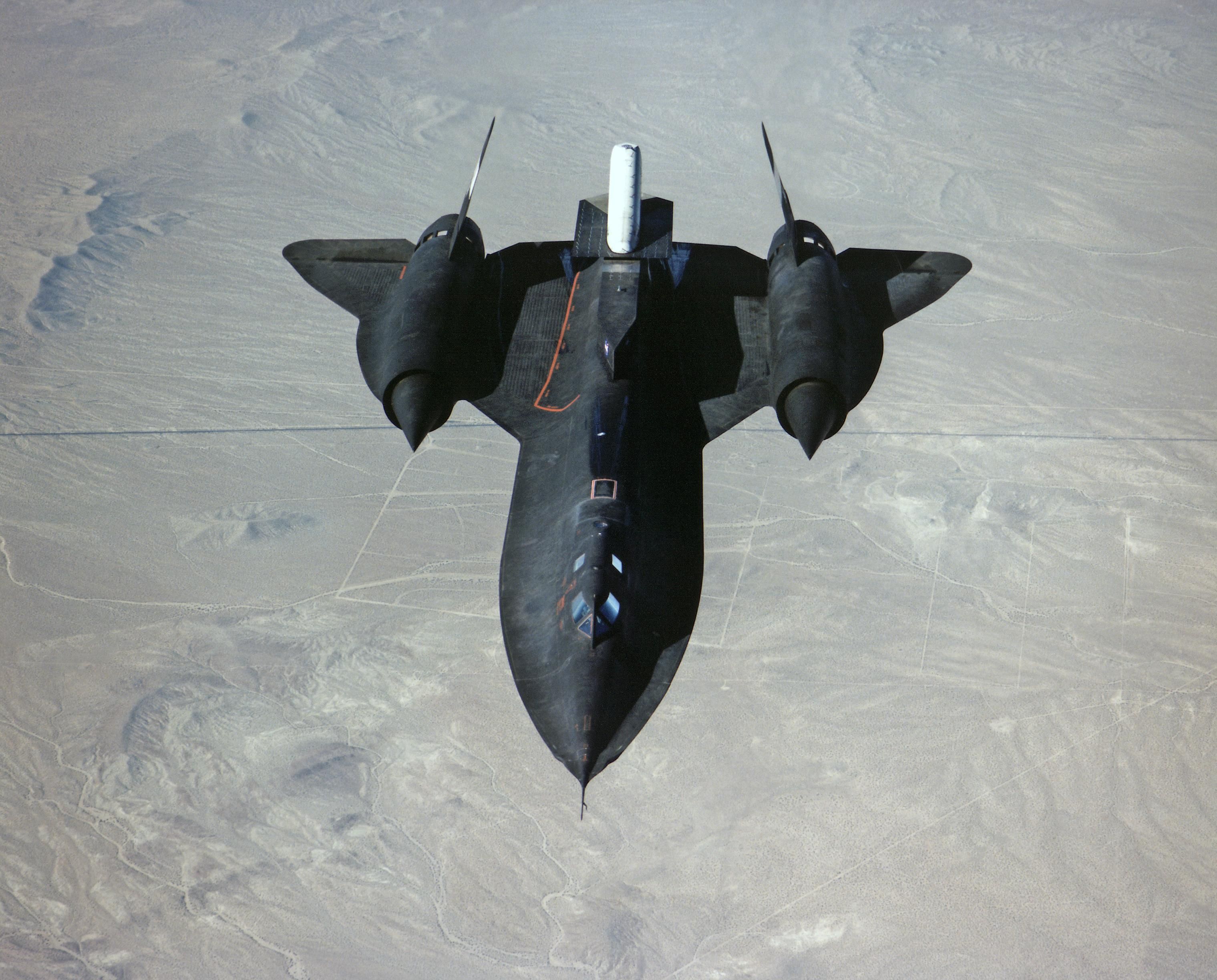 An SR-71 flying over desert terrain.