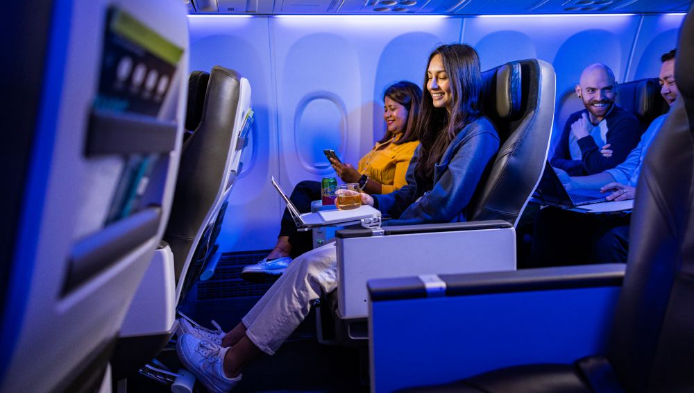 Multiple passengers sitting in an Alaska Airlines premium cabin.