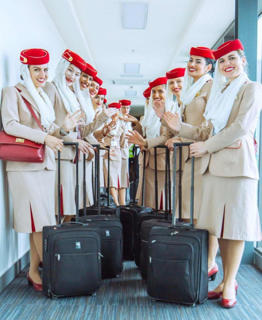 Emirates cabin crew with bags in the airport.