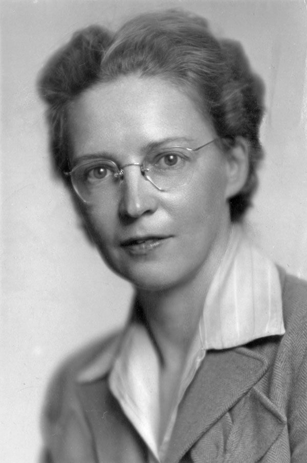 A woman wearing eyeglasses and blazer over a light-colored blouse