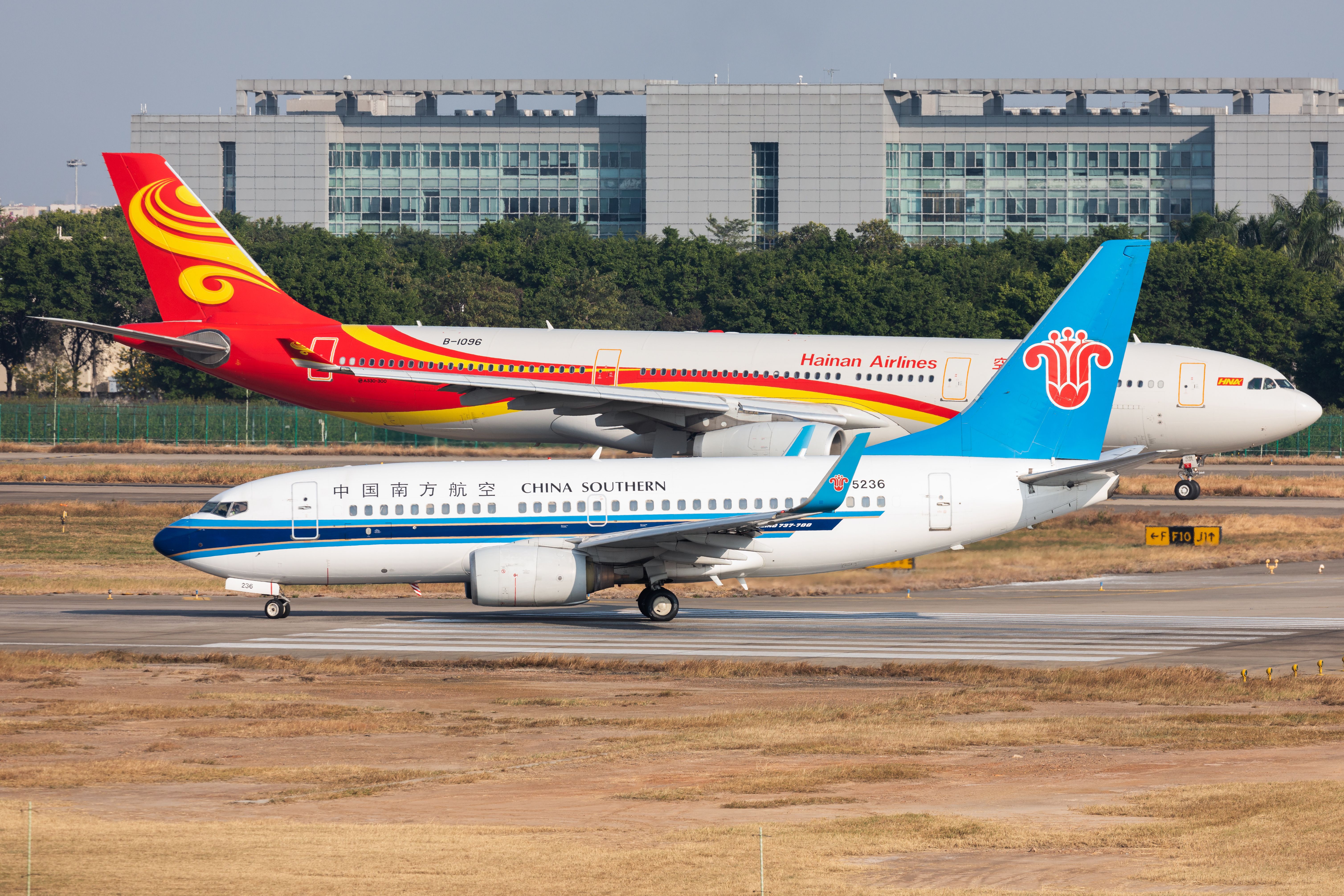 A Hainan Airlines Airbus A330-300 aircraft (back) and a China Southern Airlines Boeing 737-700 aircraft taxis at Guangzhou Baiyun International Airport on December 4, 2020 in Guangzhou, Guangdong Province of China.