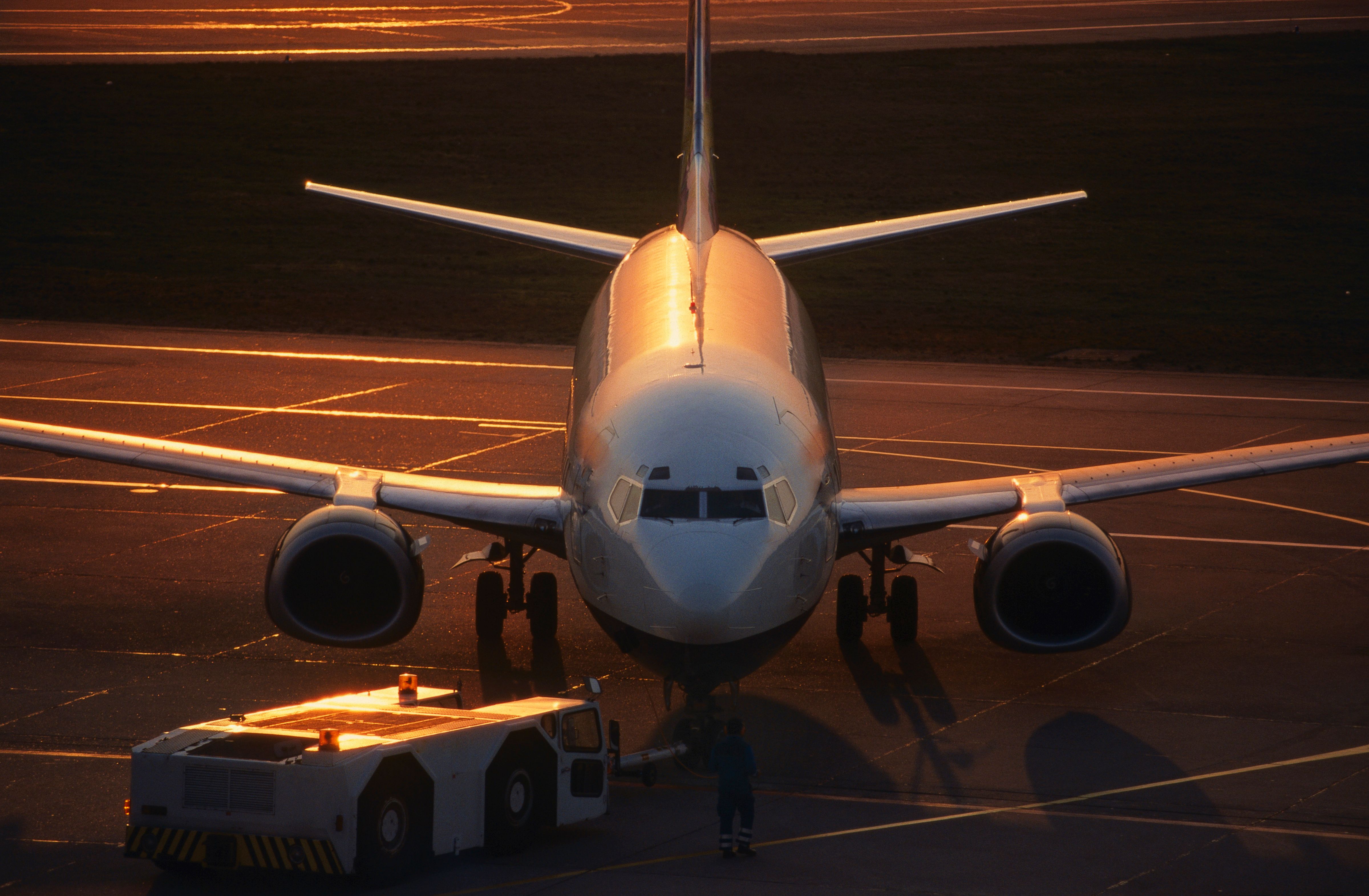 Boeing 737-300 being pushed-back by a tug at dusk