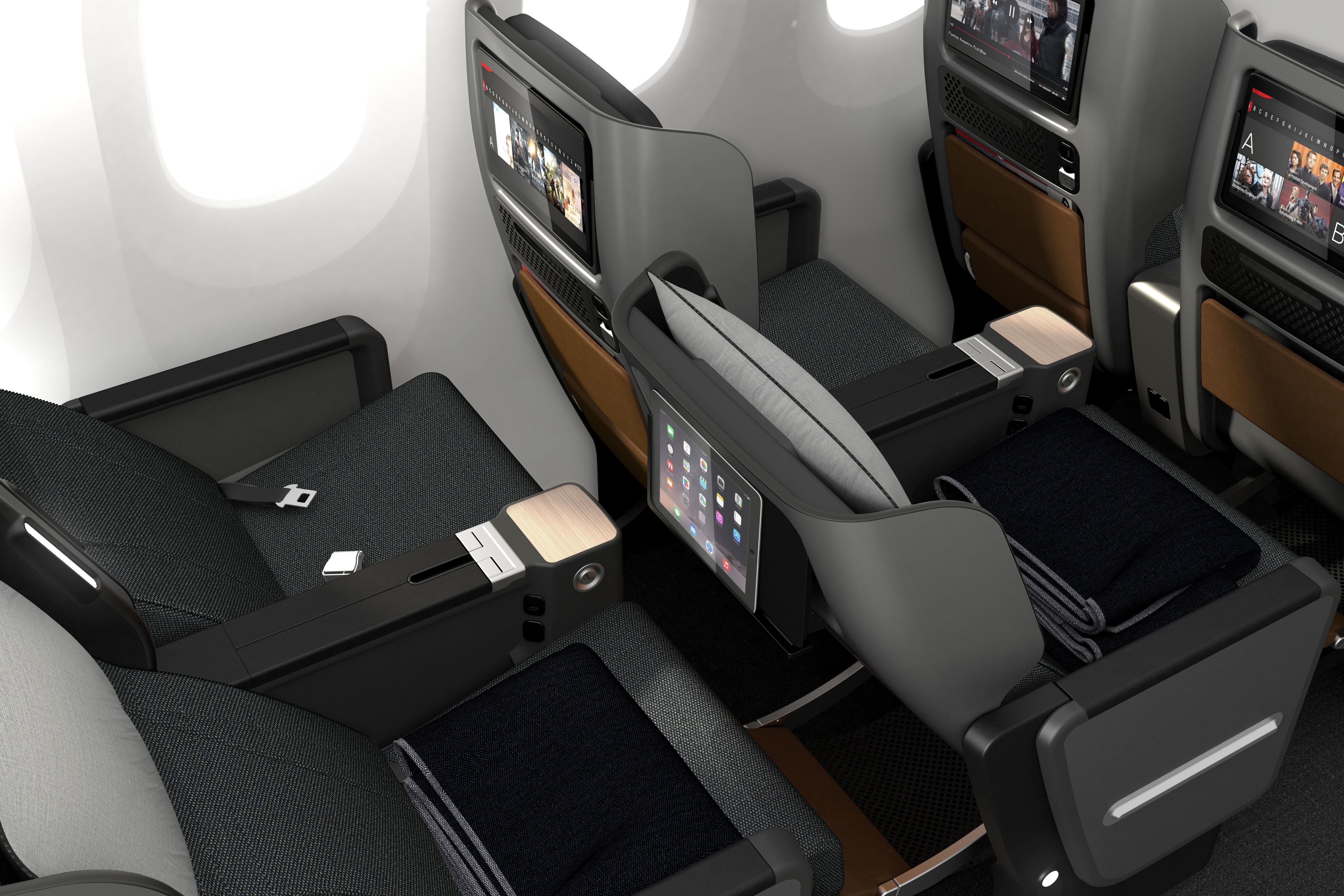 Black and grey airplane seats with entertainment screens built into back of the seats