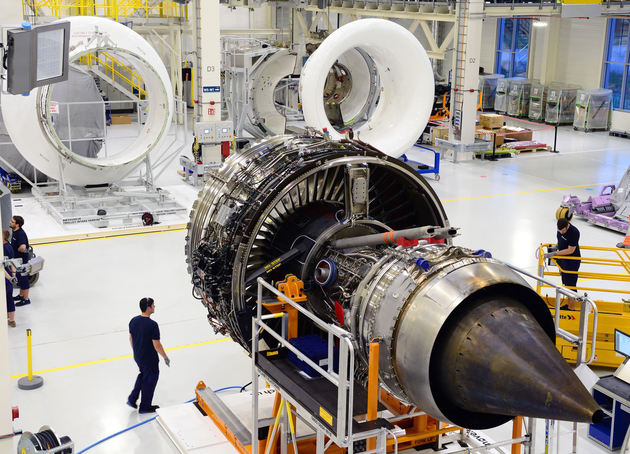 Engineers and jet engines inside Rolls Royce's Trent Engine Production facility.