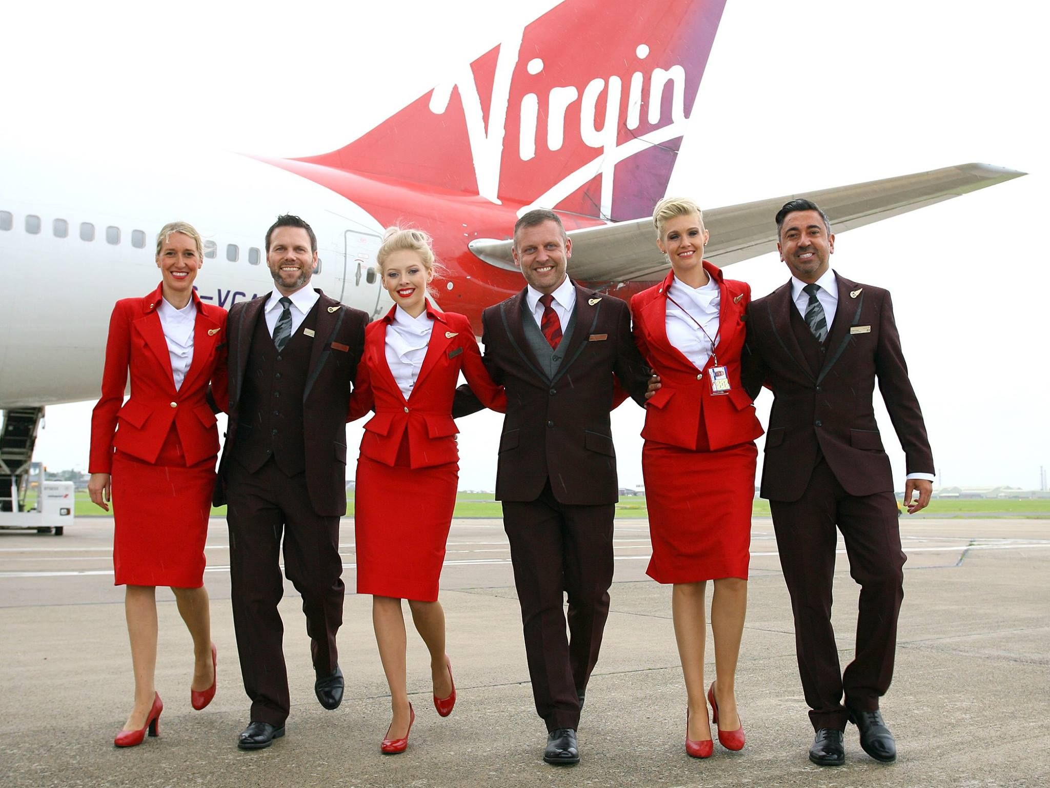 Virgin atlantic cabin crew walking in front of an aircraft.