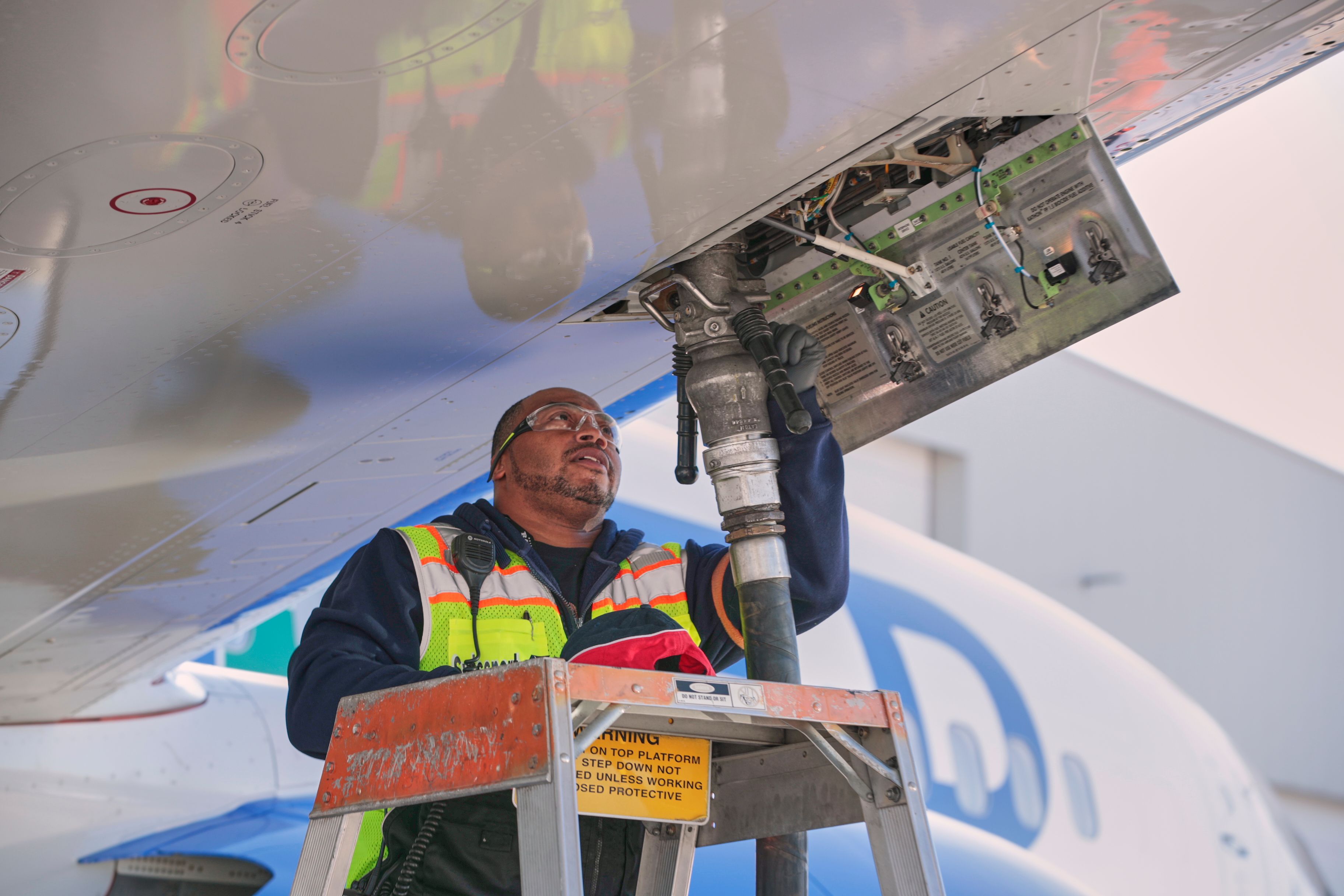 A ground crew worker refueling an aircraft.