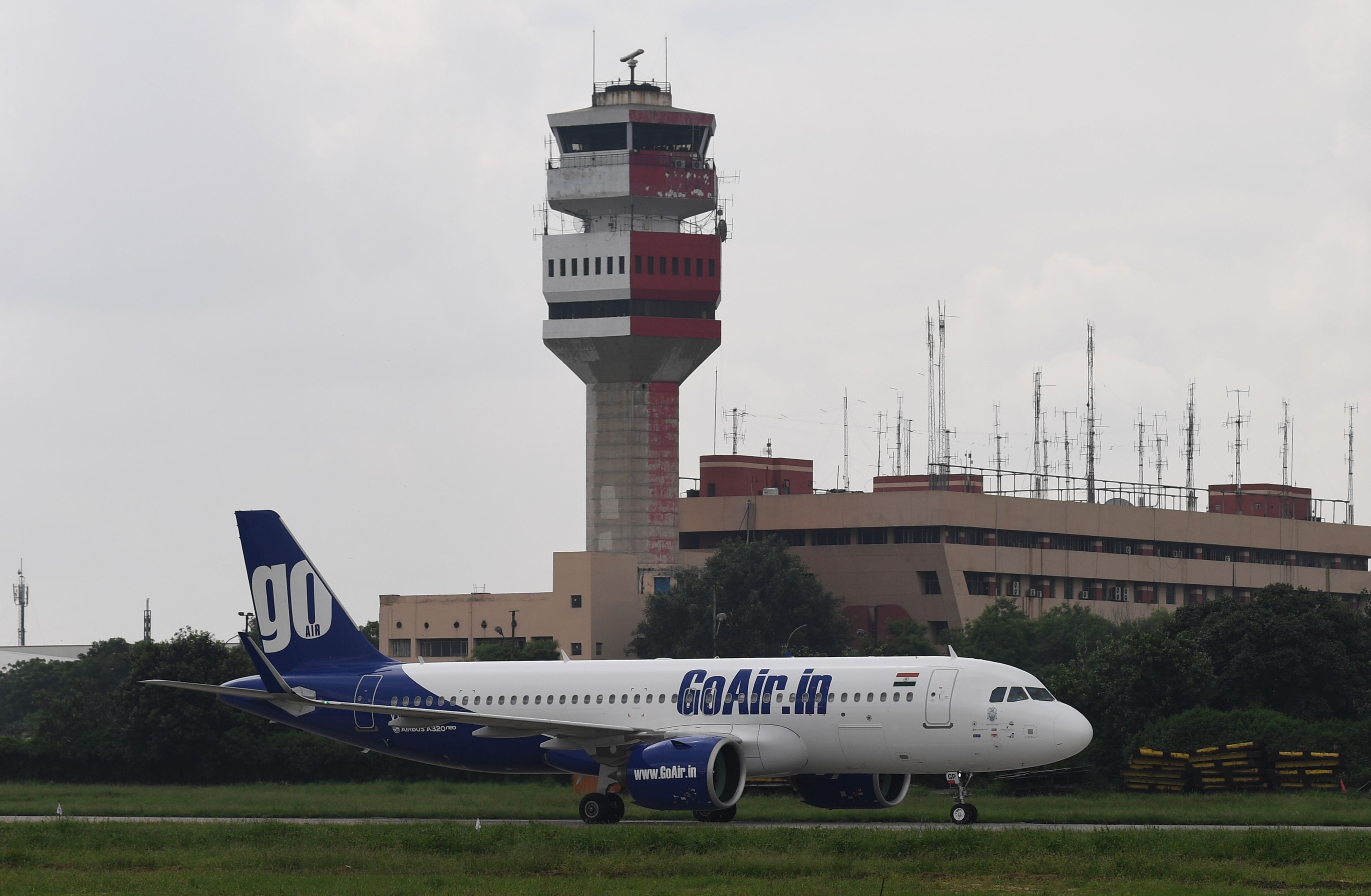A Go First plane taxis past a control tower at Indira Gandhi International Airport in New Delhi