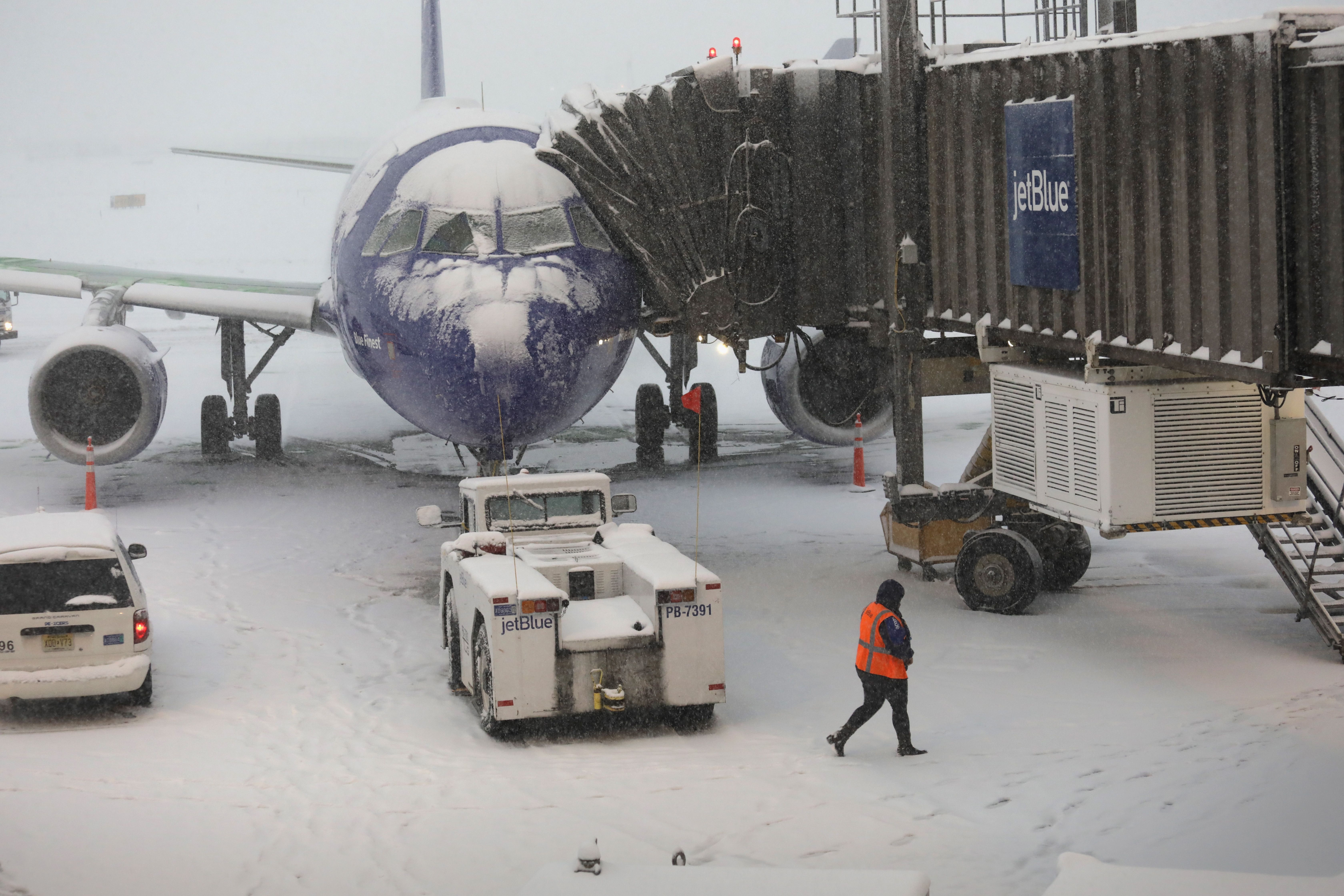  A ground crew member walks past a cancelled [JetBlue] flight due to a snow storm at the Newark Liberty International Airport on November 15, 2018 in Newark, New Jersey. The early season storm caused flight cancellations in much of the northeast