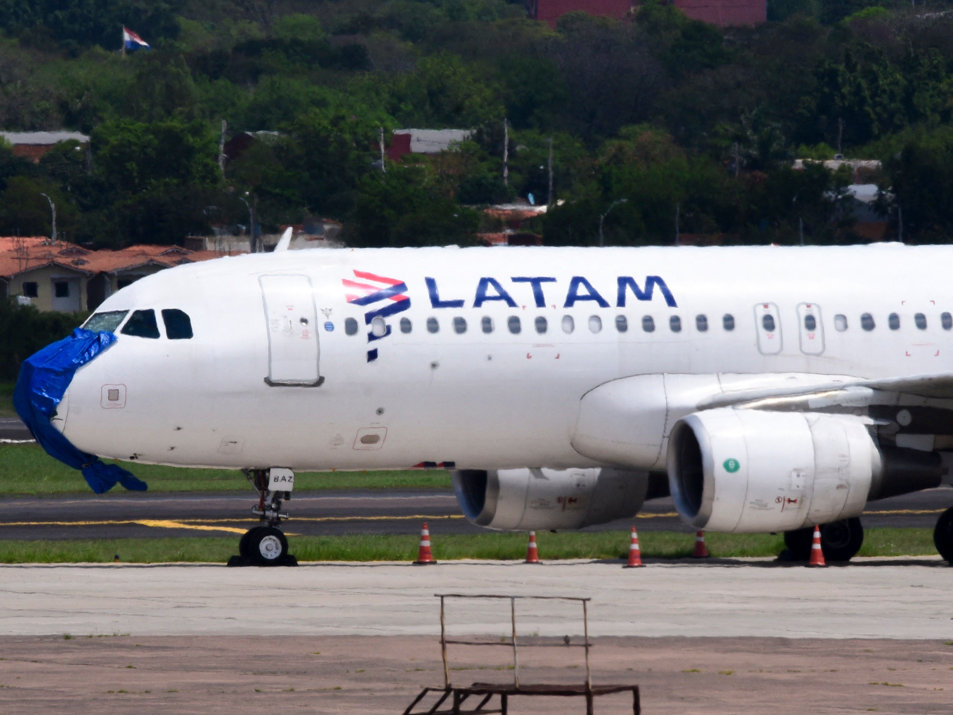 A Latam Airlines plane is pictured after an emergency landing on the eve at Silvio Pettirossi International Airport in Luque, Paraguay, on October 27, 2022. - A Chilean-Brazilian airline Latam plane with 48 passengers on board made an emergency landing in Luque at midnight on October 26 without an engine and with serious damage after flying through a severe storm, Paraguayan authorities said on October 27. 
