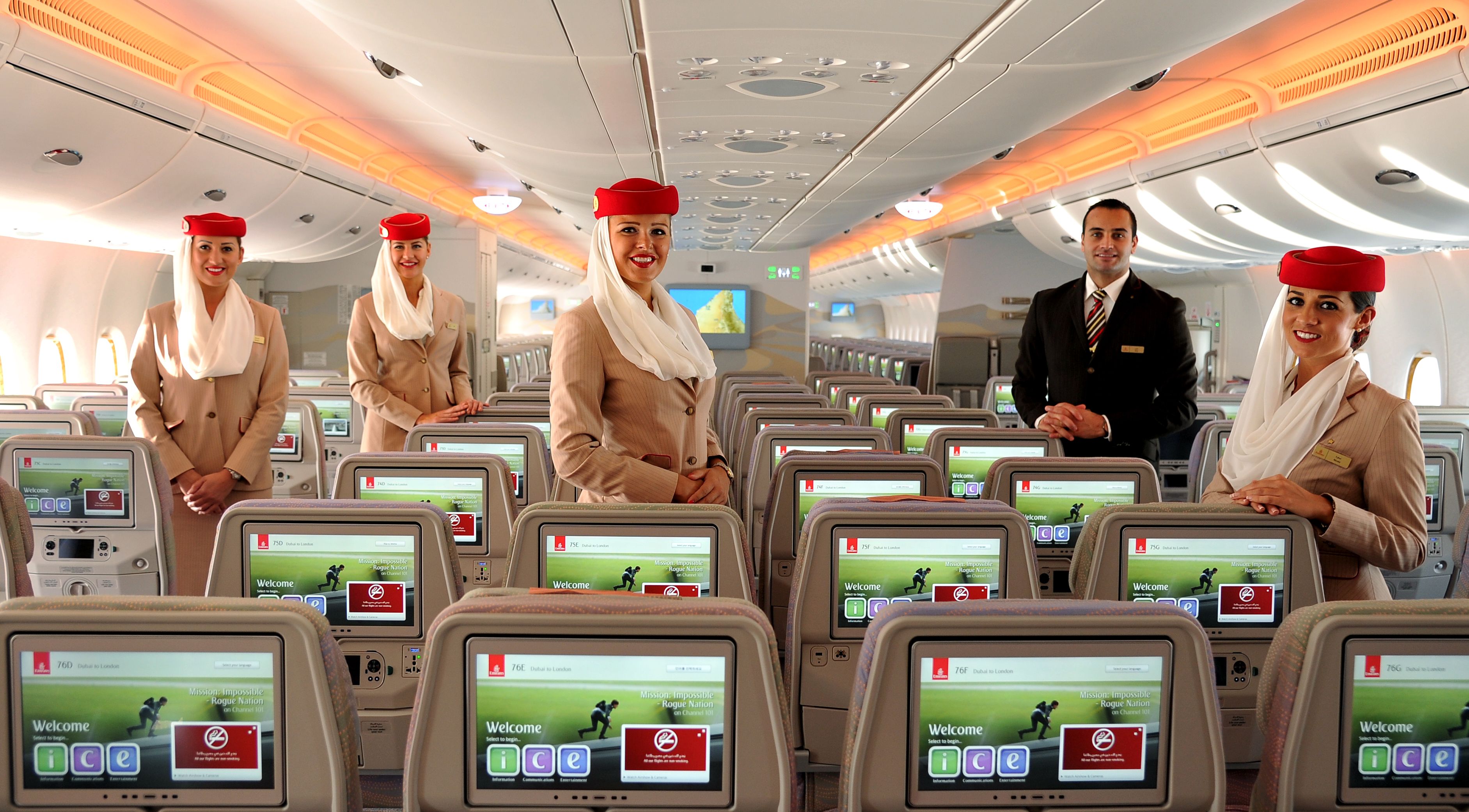 Emirates cabin crew standing in the aircraft cabin.