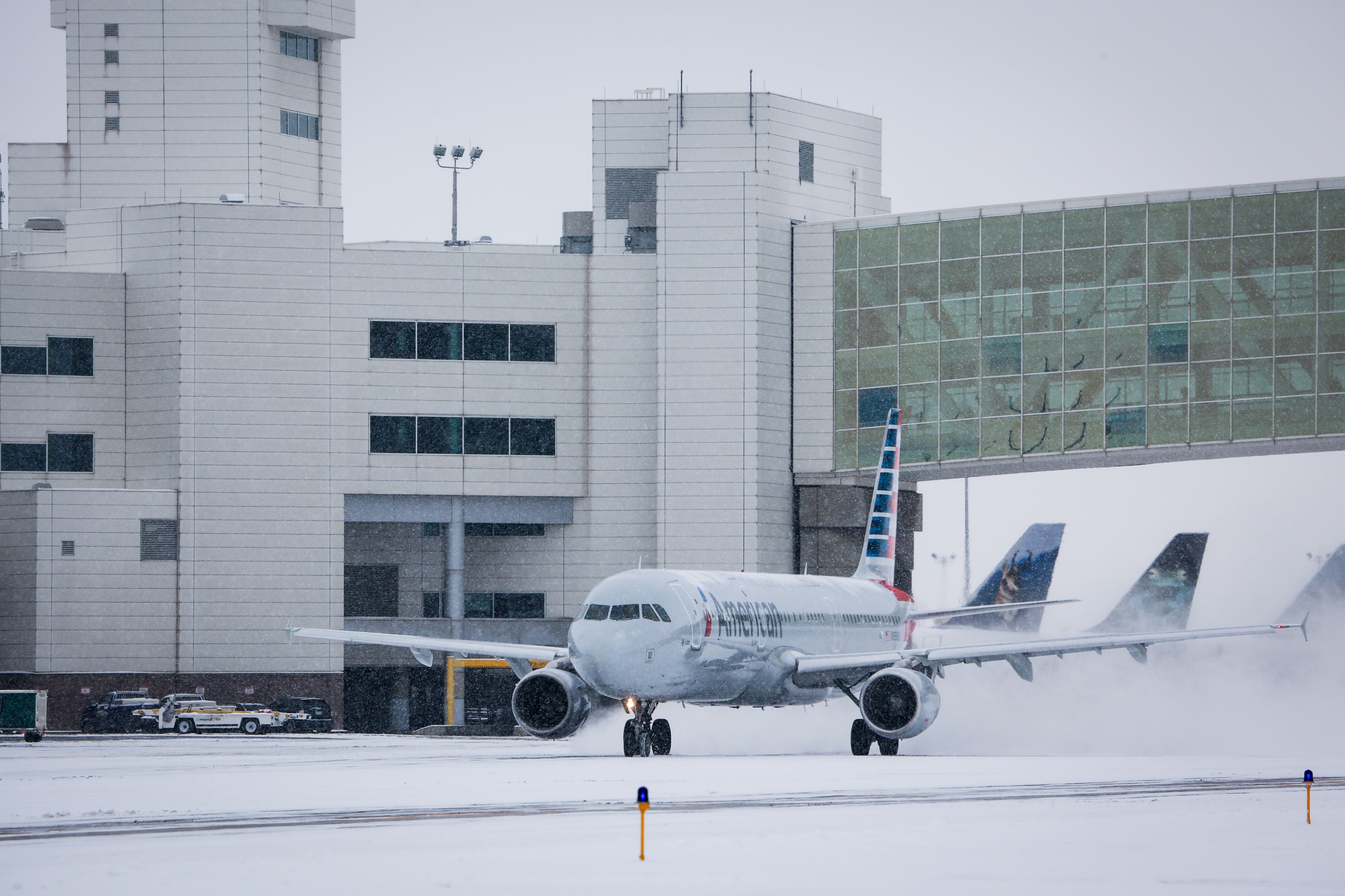 American Airlines aircraft taxis through snow