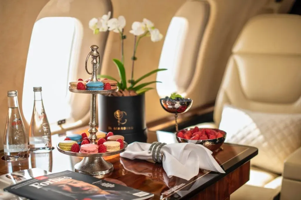 A table set up with exquisite snacks and drinks onboard a private jet.
