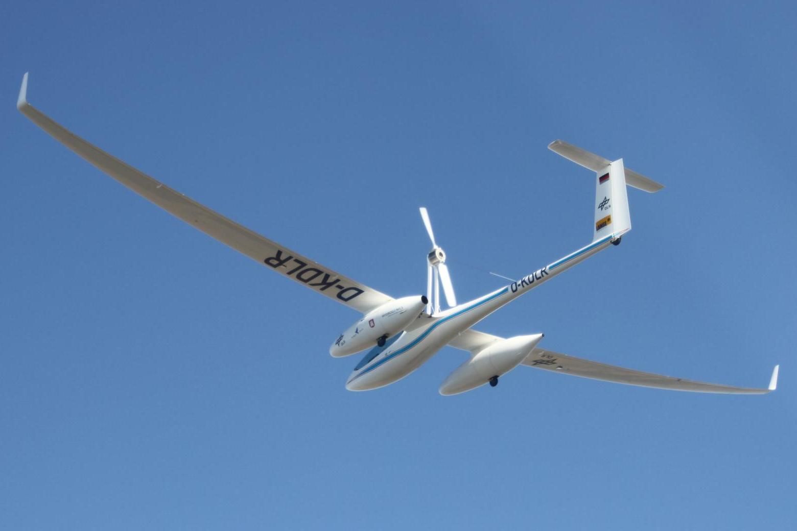 The Antares DLR-H2 research aircraft, powered by a hydrogen fuel cell, flying in the sky.