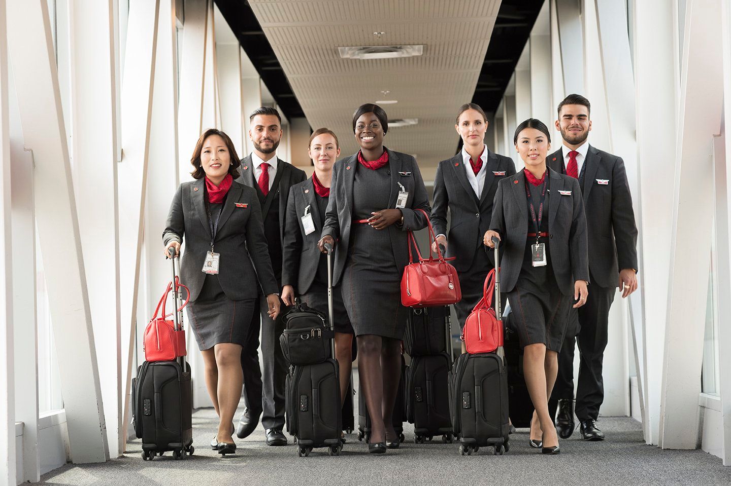 A group of Air Canada flight attendants walking down the jet bridge.