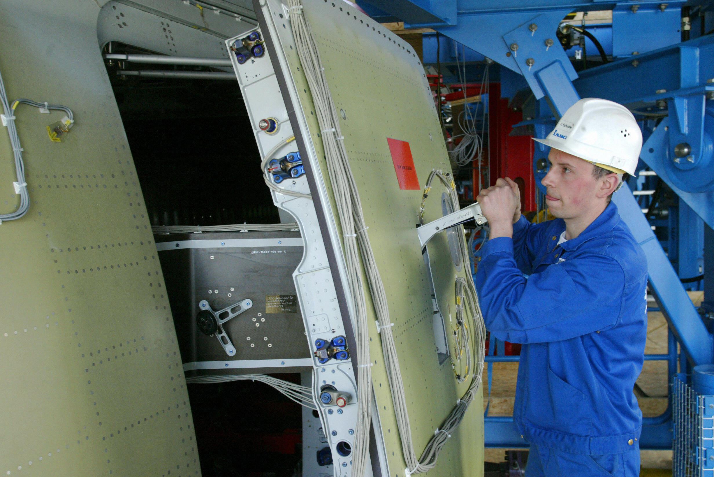 An aircraft mechanic checks the door of an Airbus A380