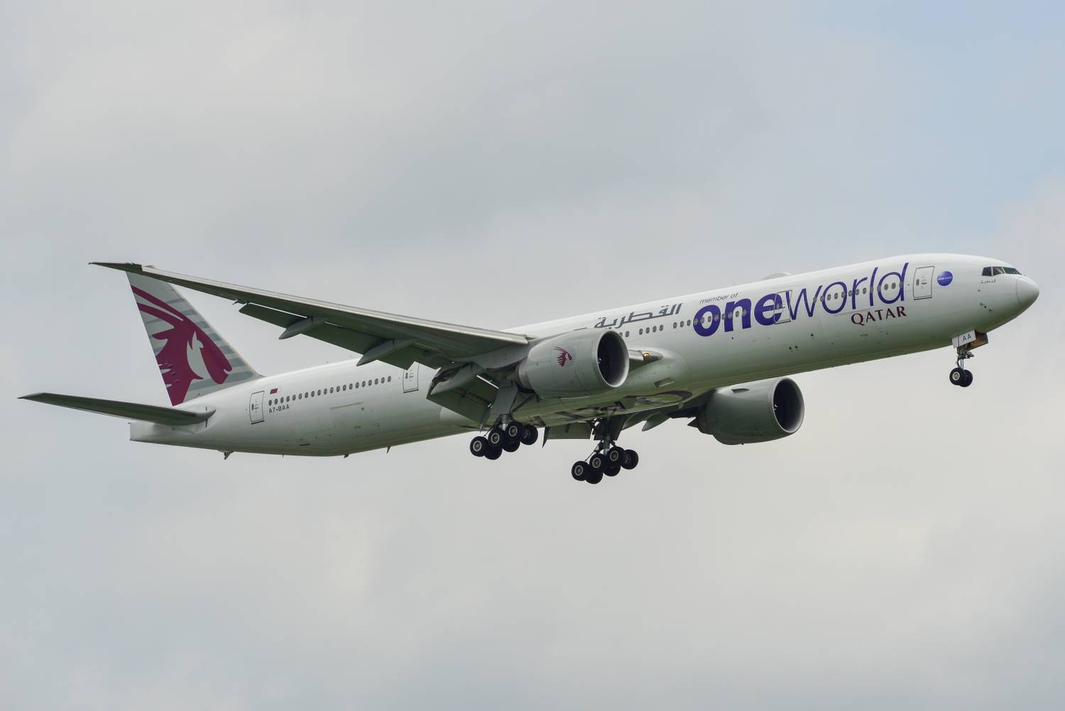 A Qatar Airways Boeing 777-300ER in oneworld Livery flying in the sky.