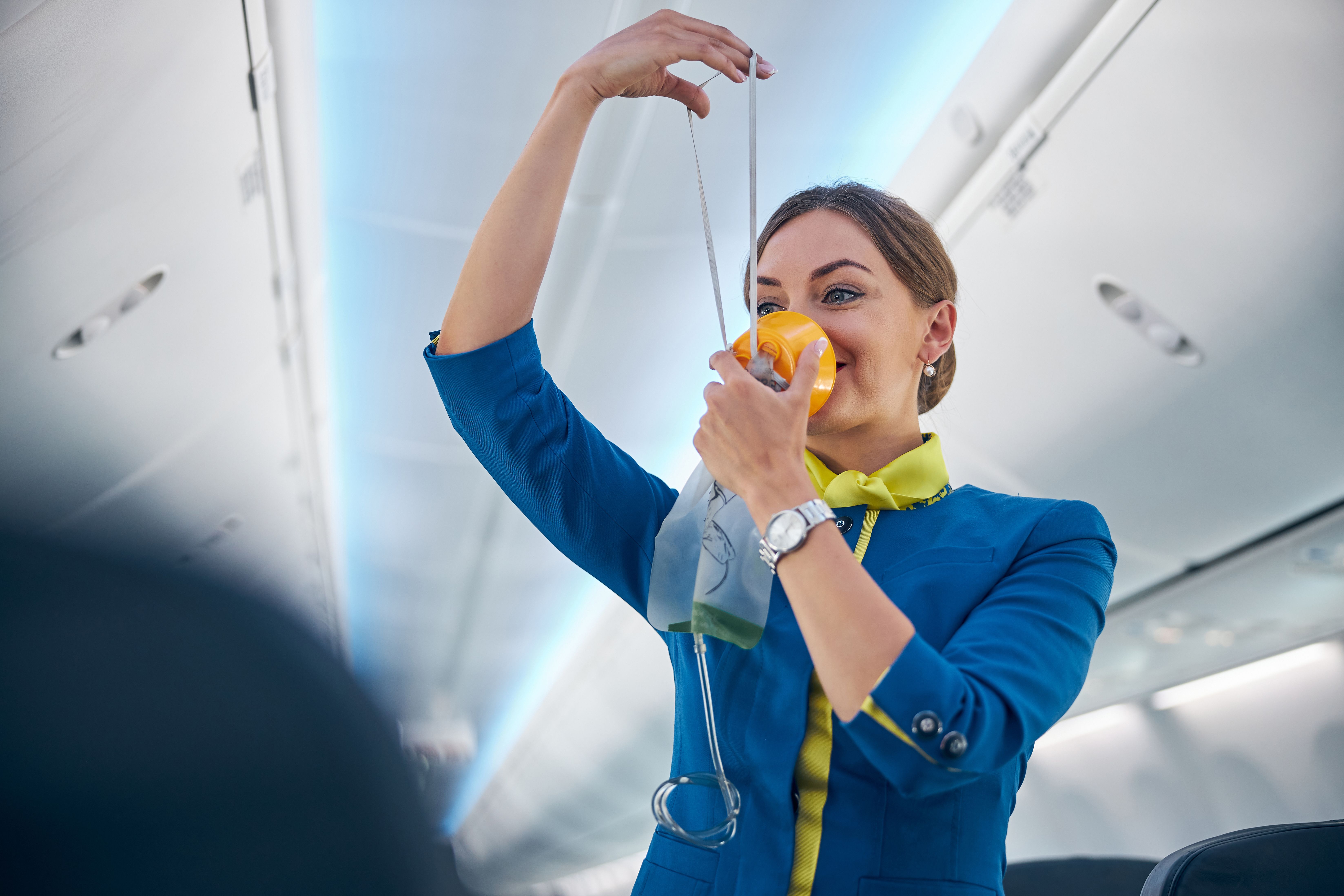 A flight attendant will demonstrate how to put on an oxygen mask.