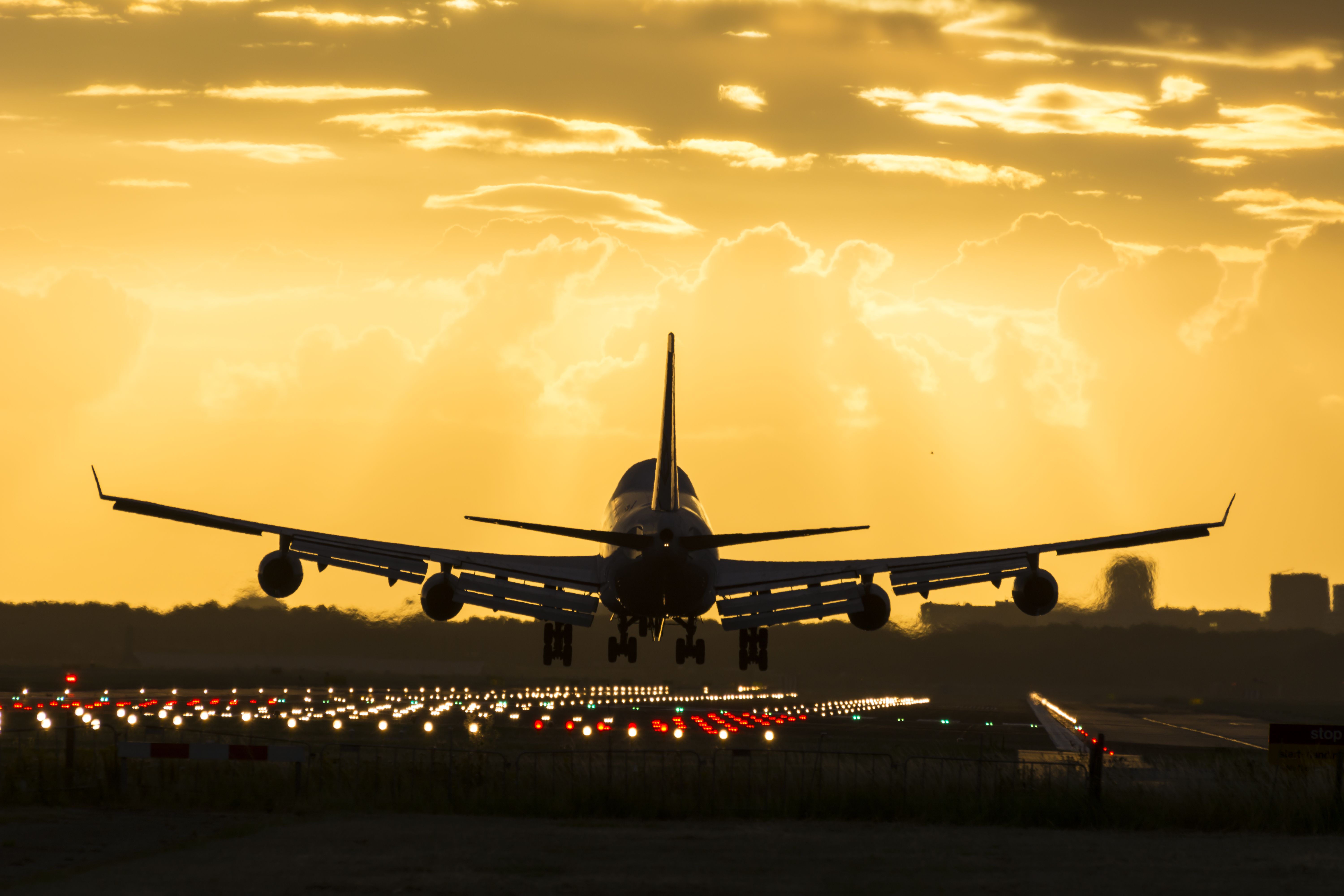 The Silhouette of a Boeing 747 landing at sunset.