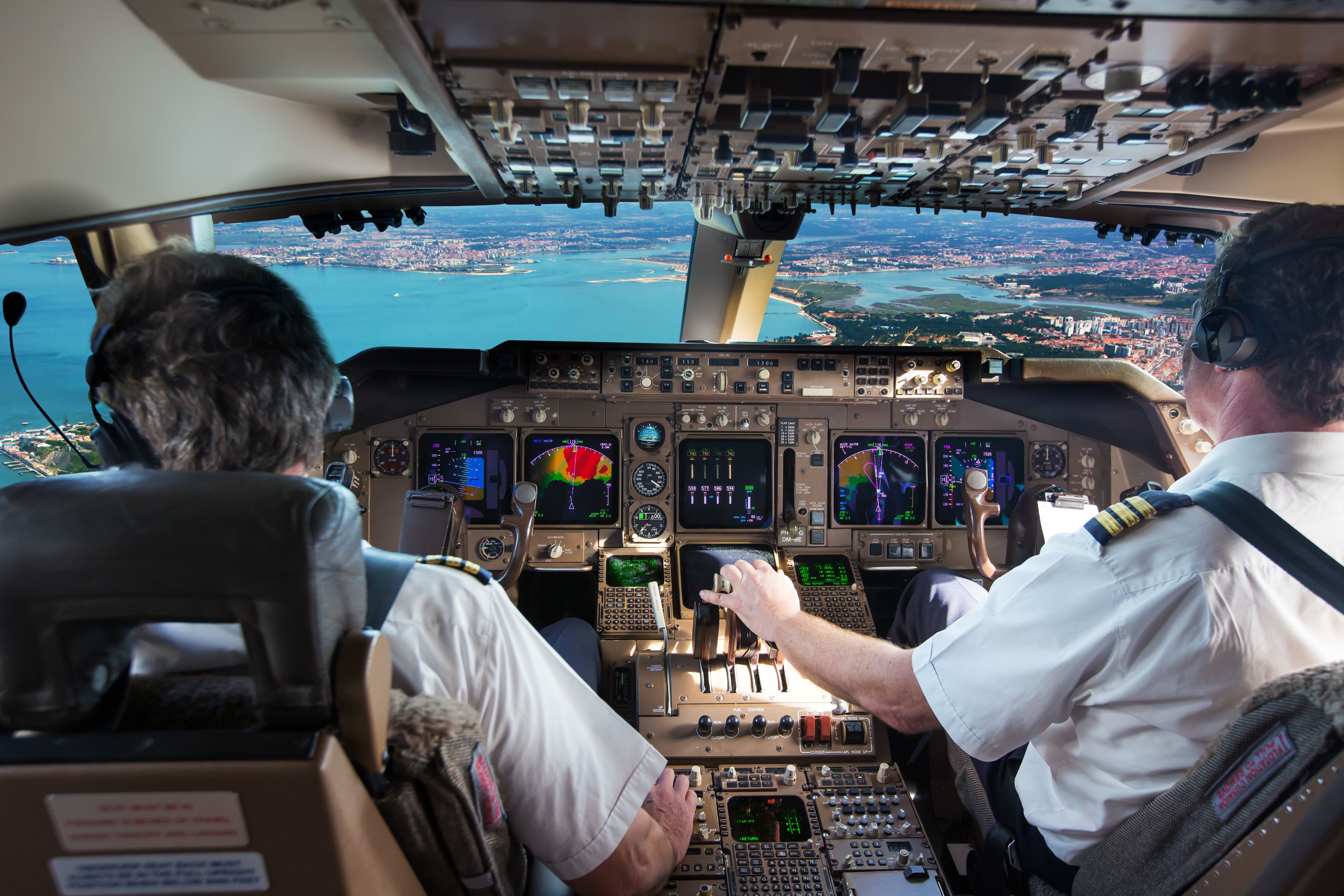 View from the cockpit of two pilots preparing to land an aircraft.