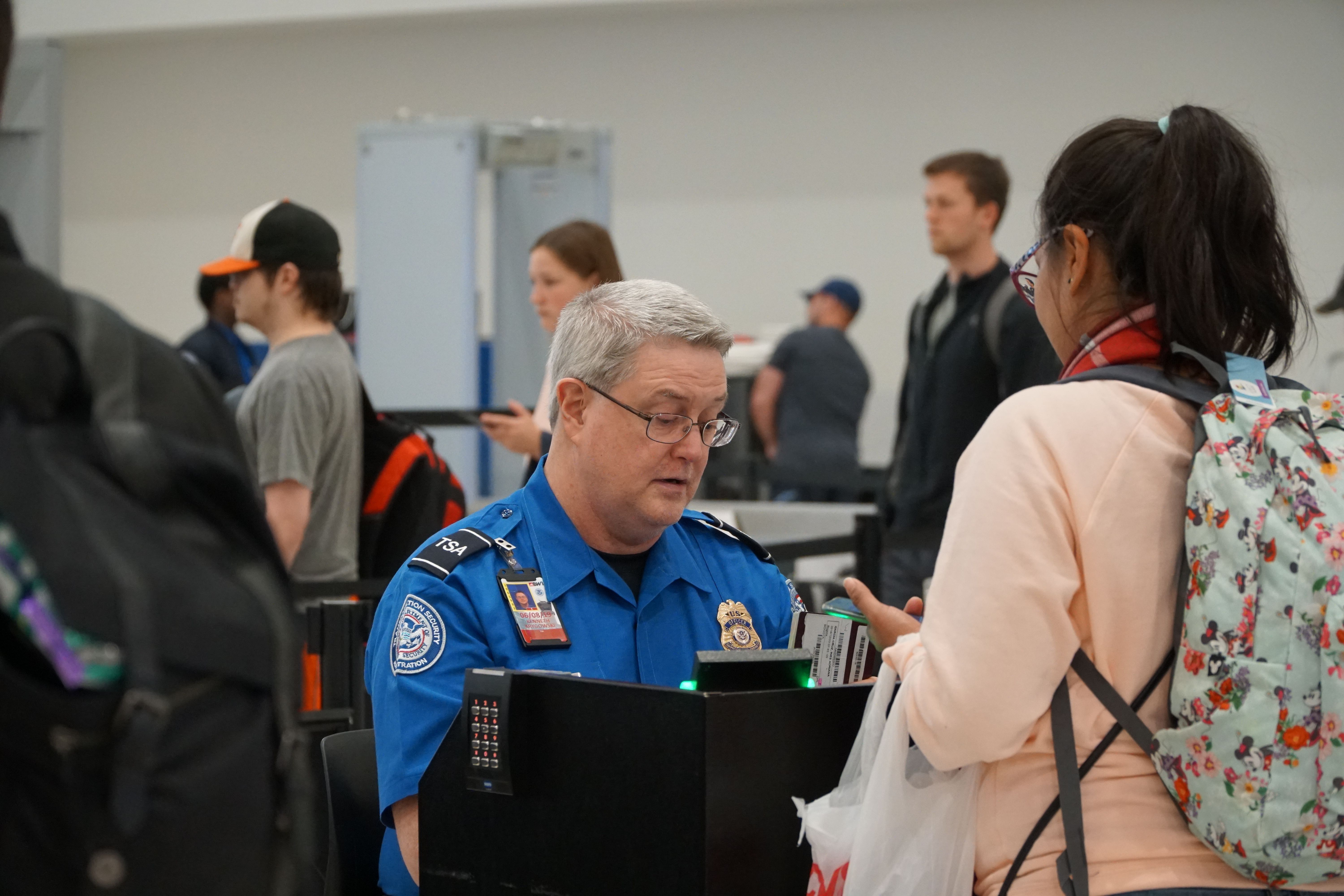 A passenger talks with a TSA agent.