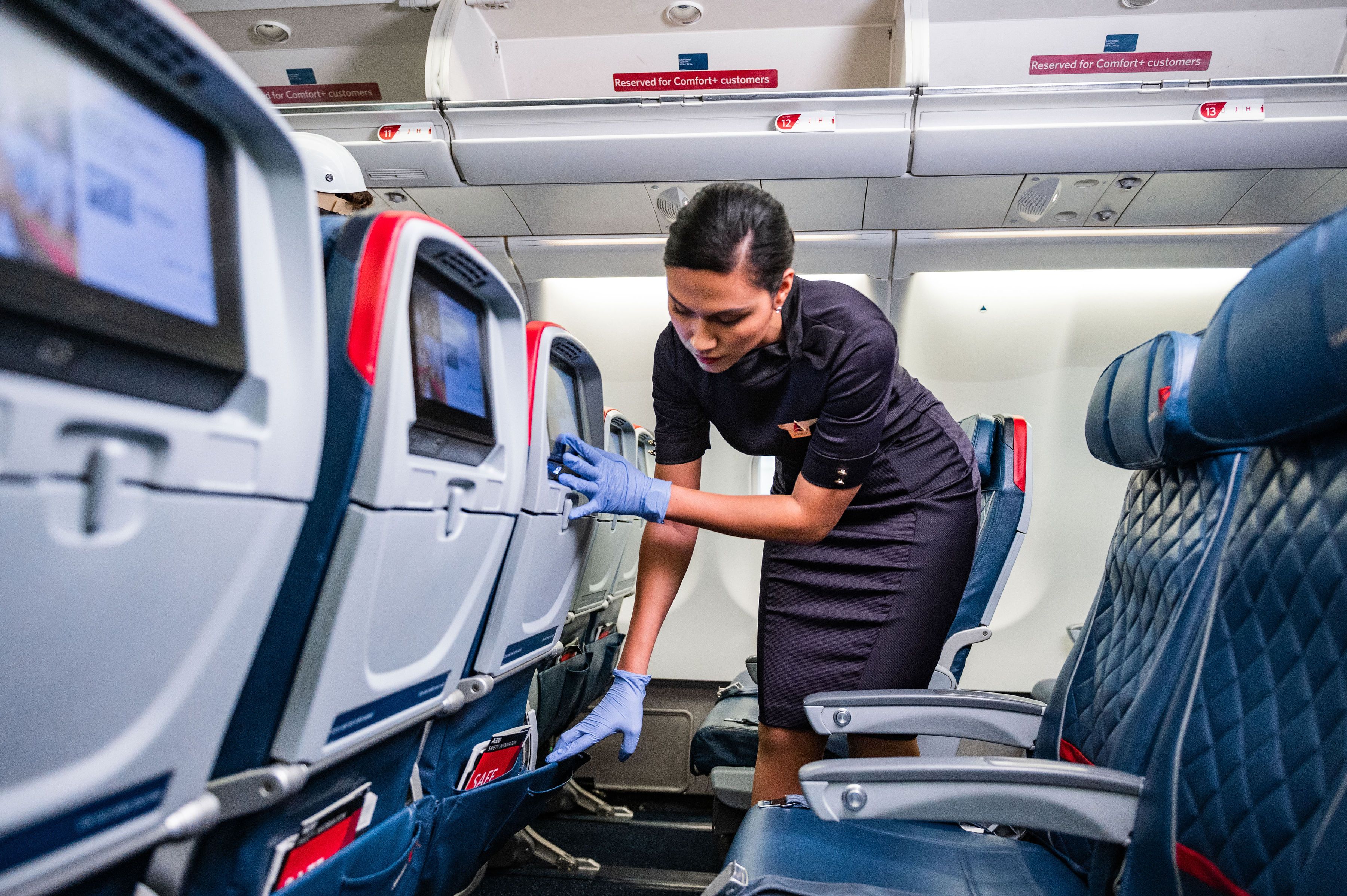 Delta Flight Attendant Wiping Down Seatback