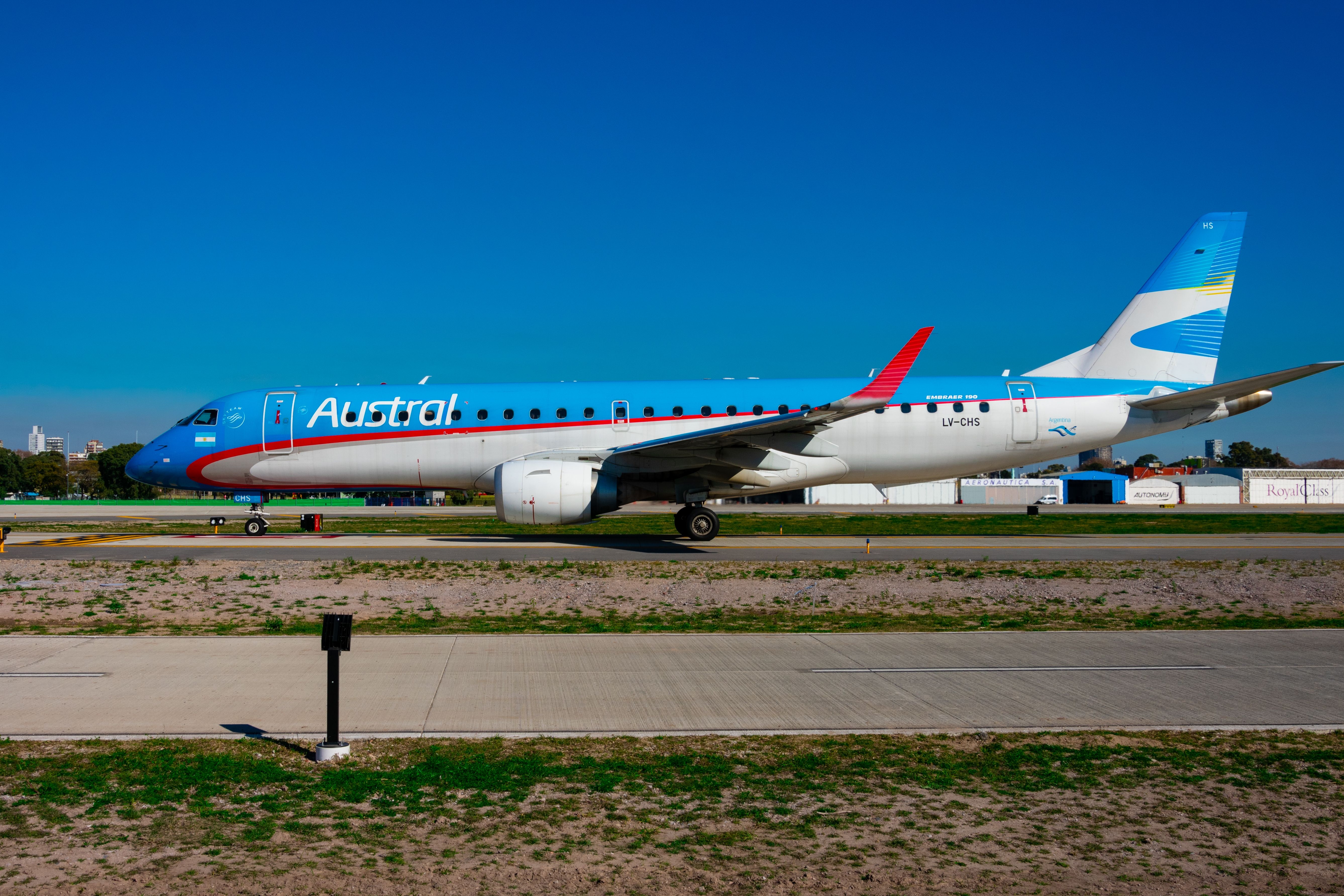 An Aerolíneas Argentinas Embraer E190 with an Austral livery parked 