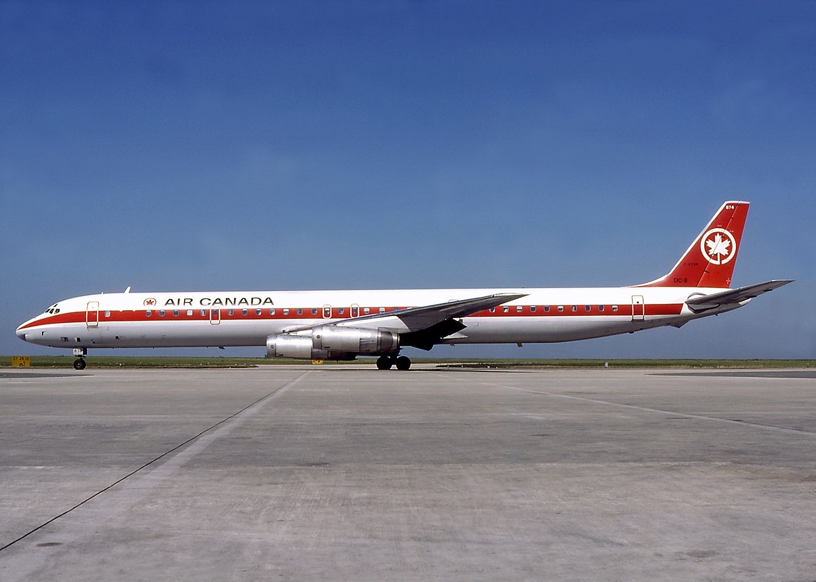 White passenger jetliner with red stripe down the side and Air Canada livery