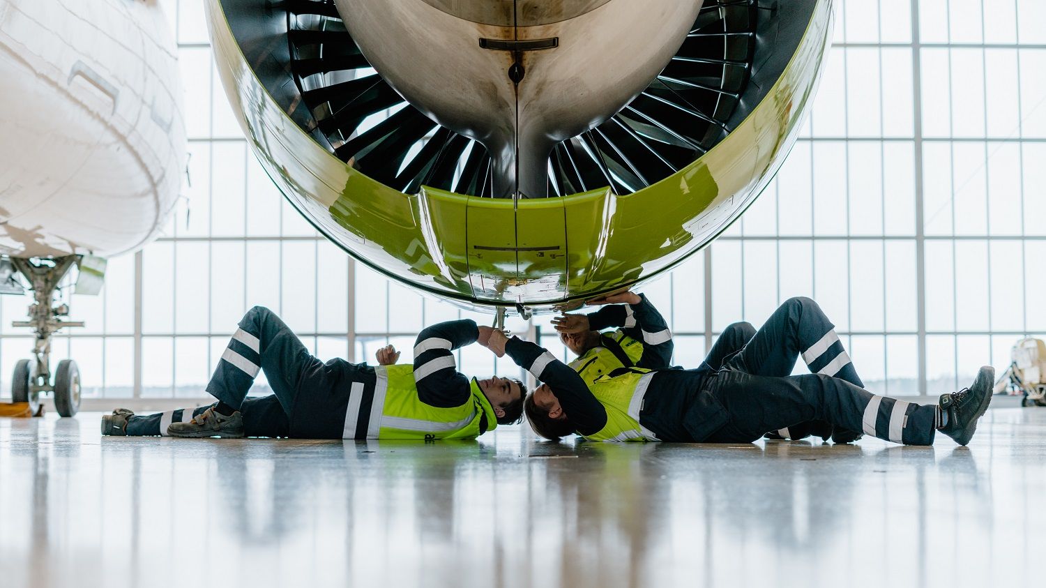 airbaltic technicians working on an airbus a220-300 engine