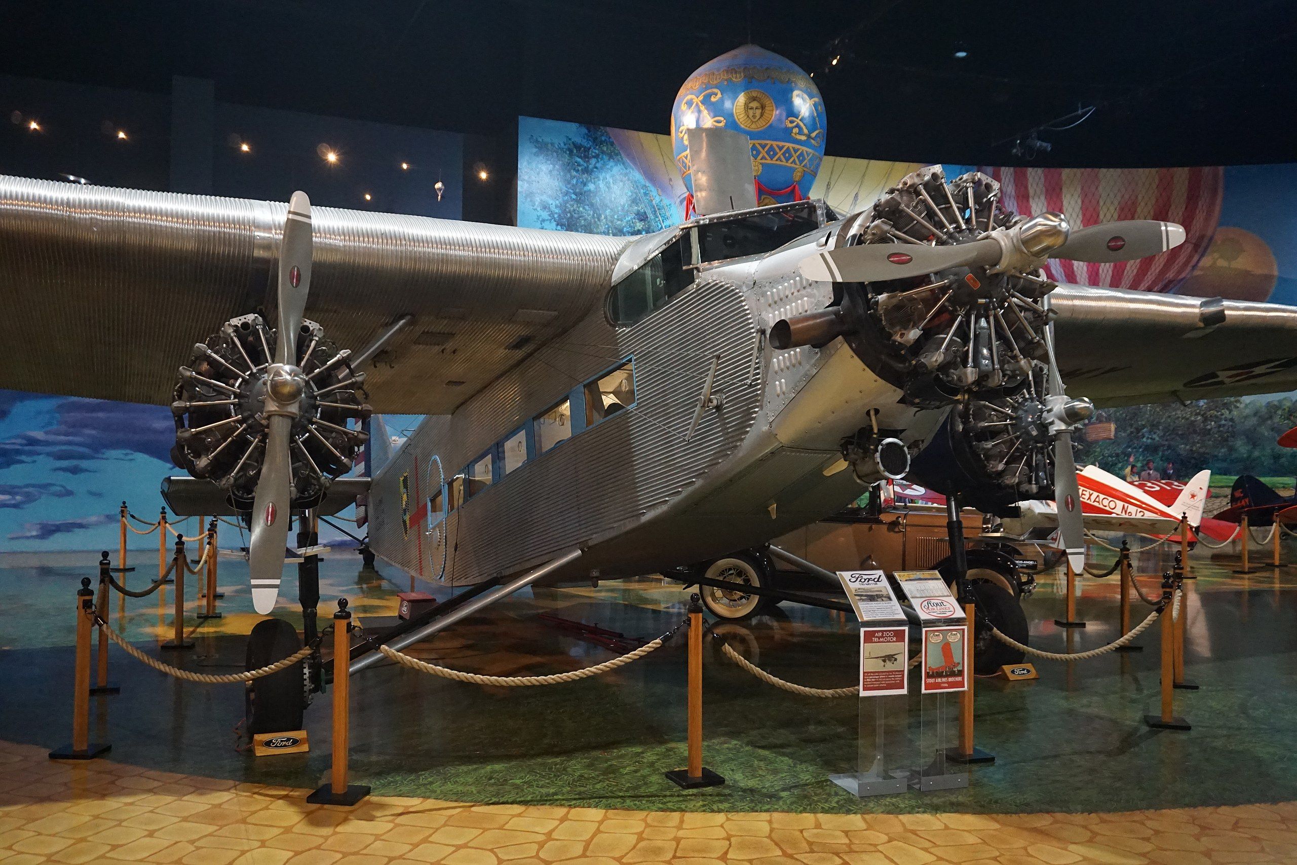 Vintage gray metal aircraft with a nose-mounted engine and beneath each wing sits in a museum