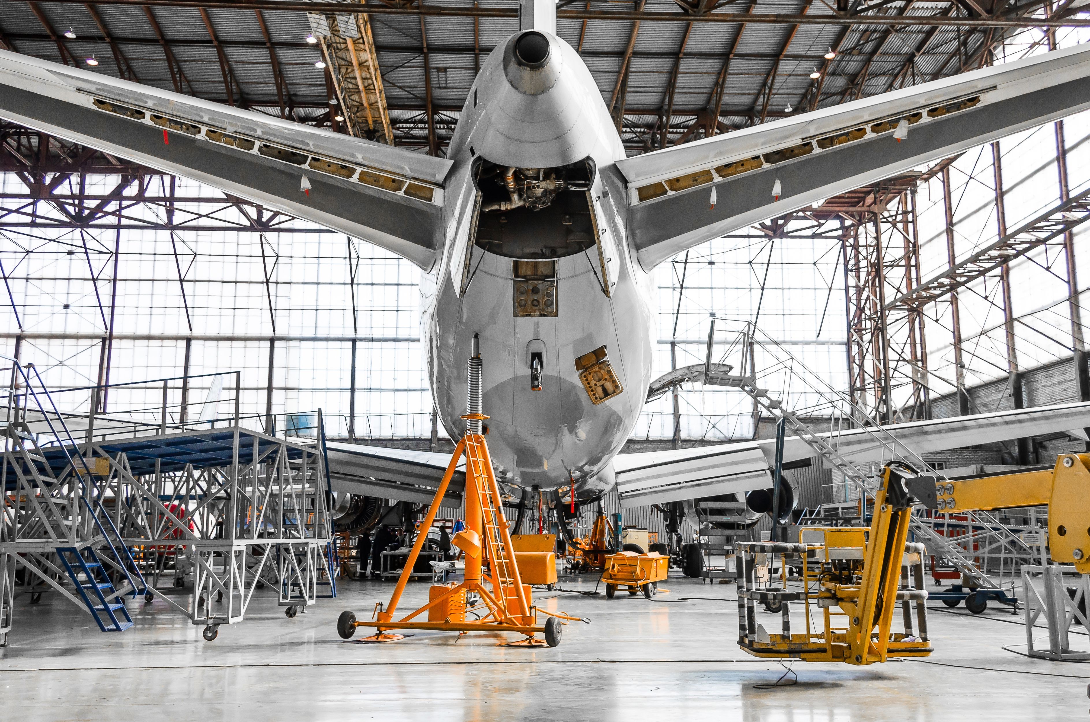 Large passenger aircraft on service in an aviation hangar rear view of the tail