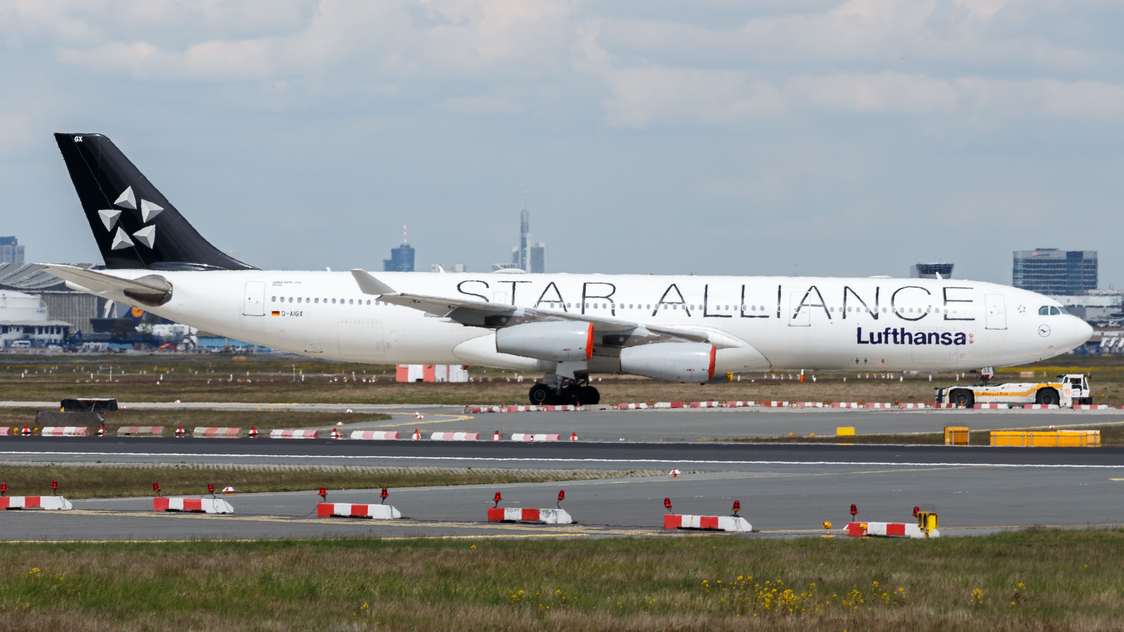 A Lufthansa Airbus A340-300 in Star Alliance liveryon an airport apron.
