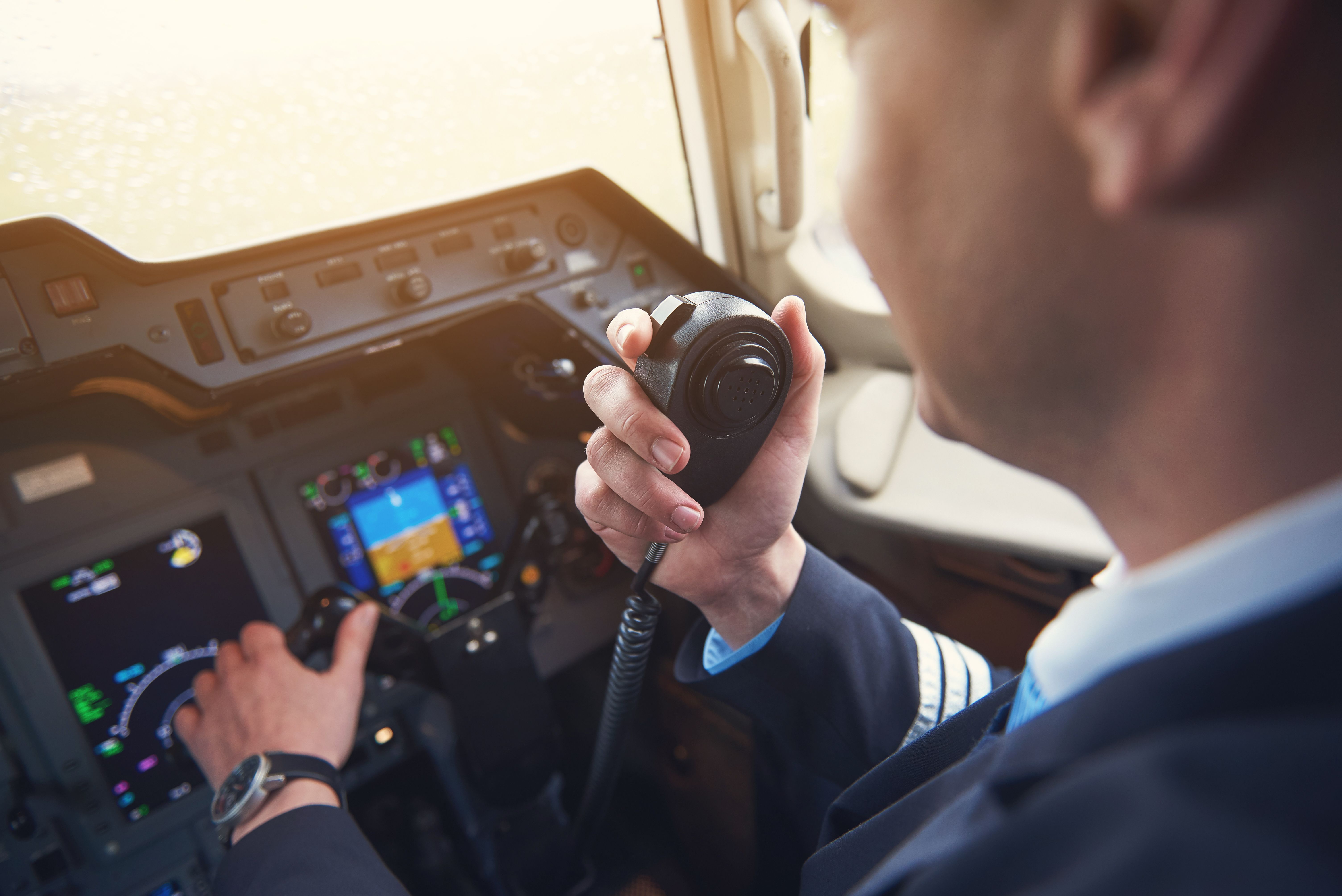 A first officer transmits using the hand-held radio.