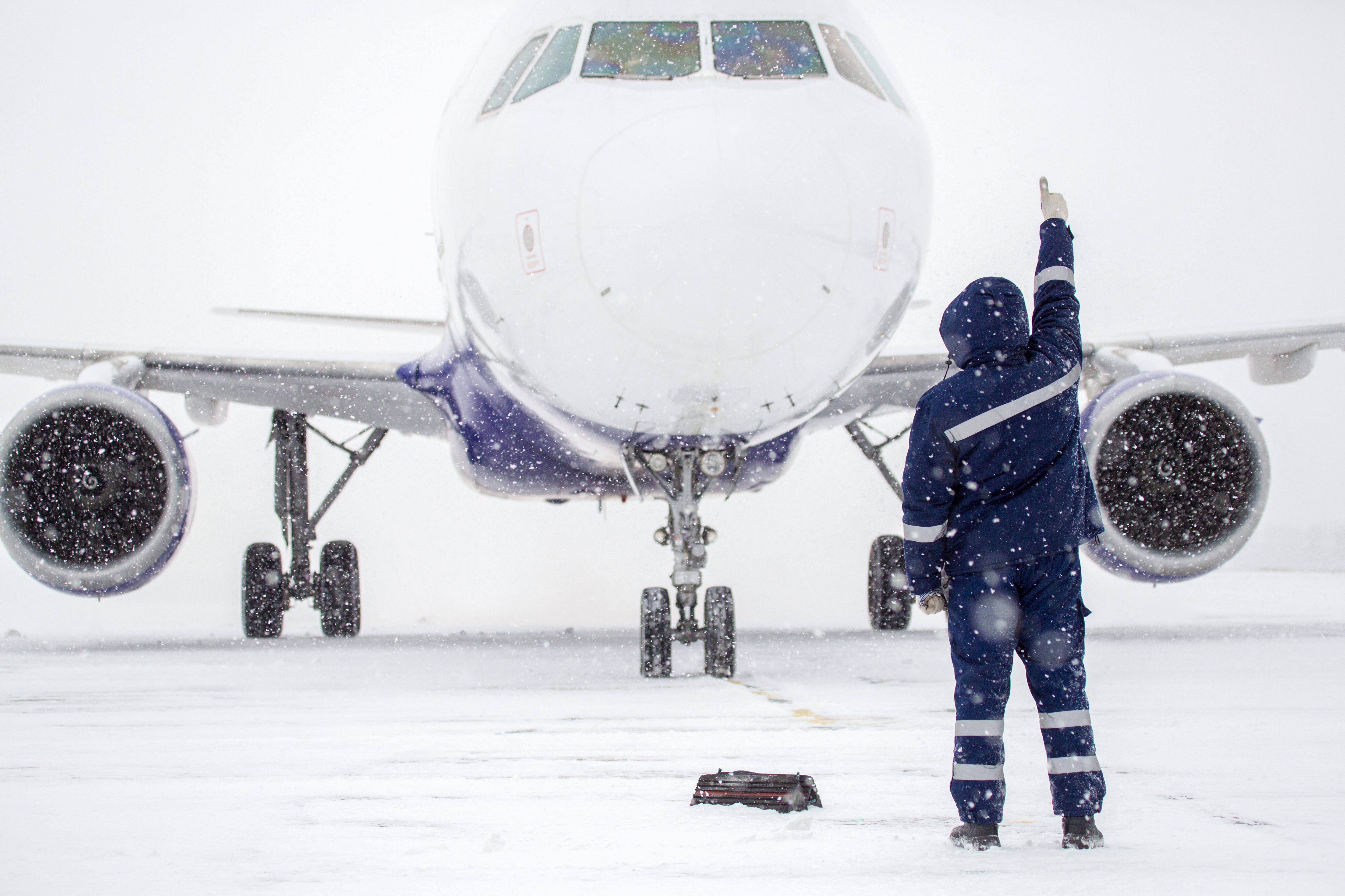 Airplane Silhouette in Snow with Ramp Agent