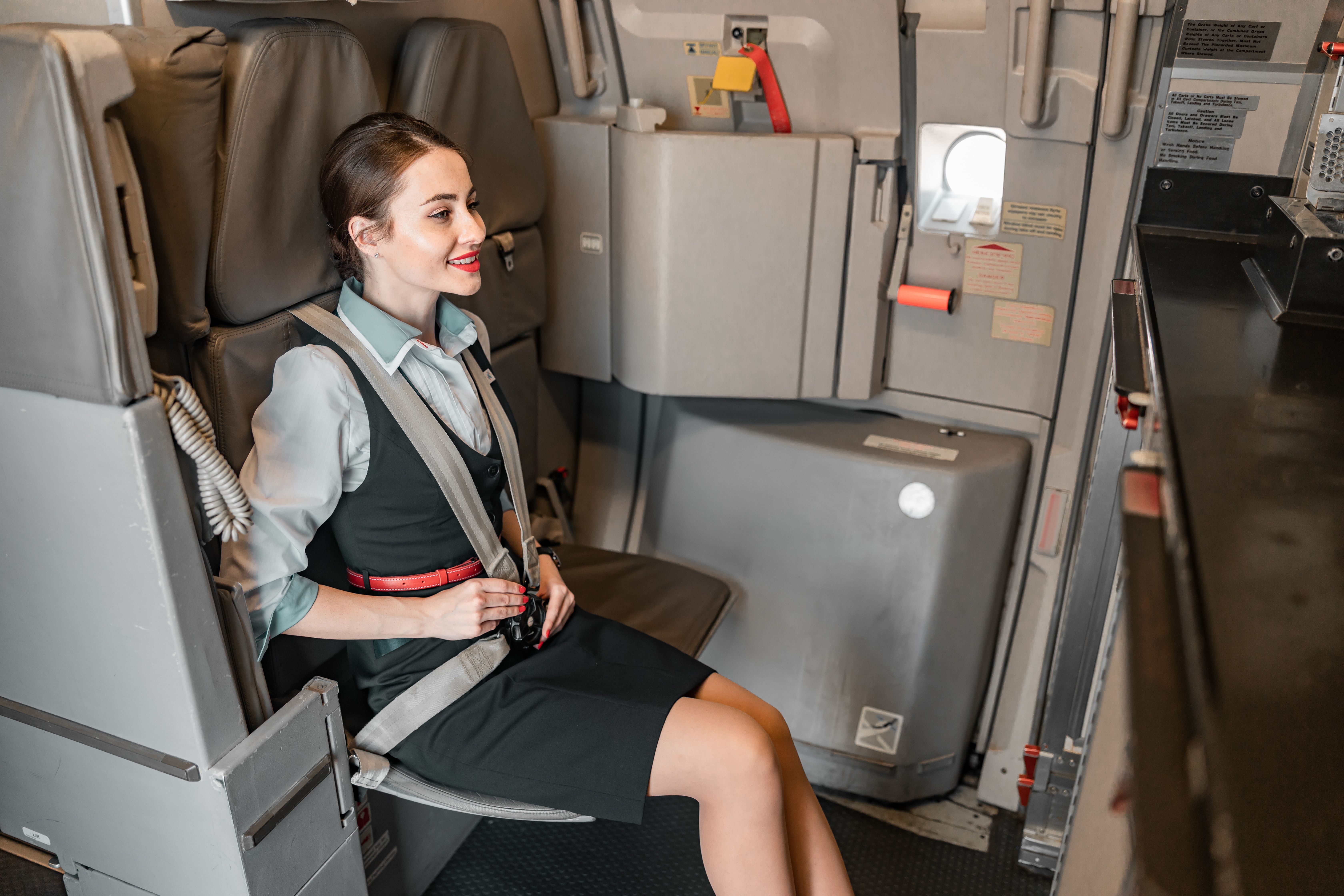 A Cabin crew member sitting in a rear ward facing aft galley seat on the Airbus A320.