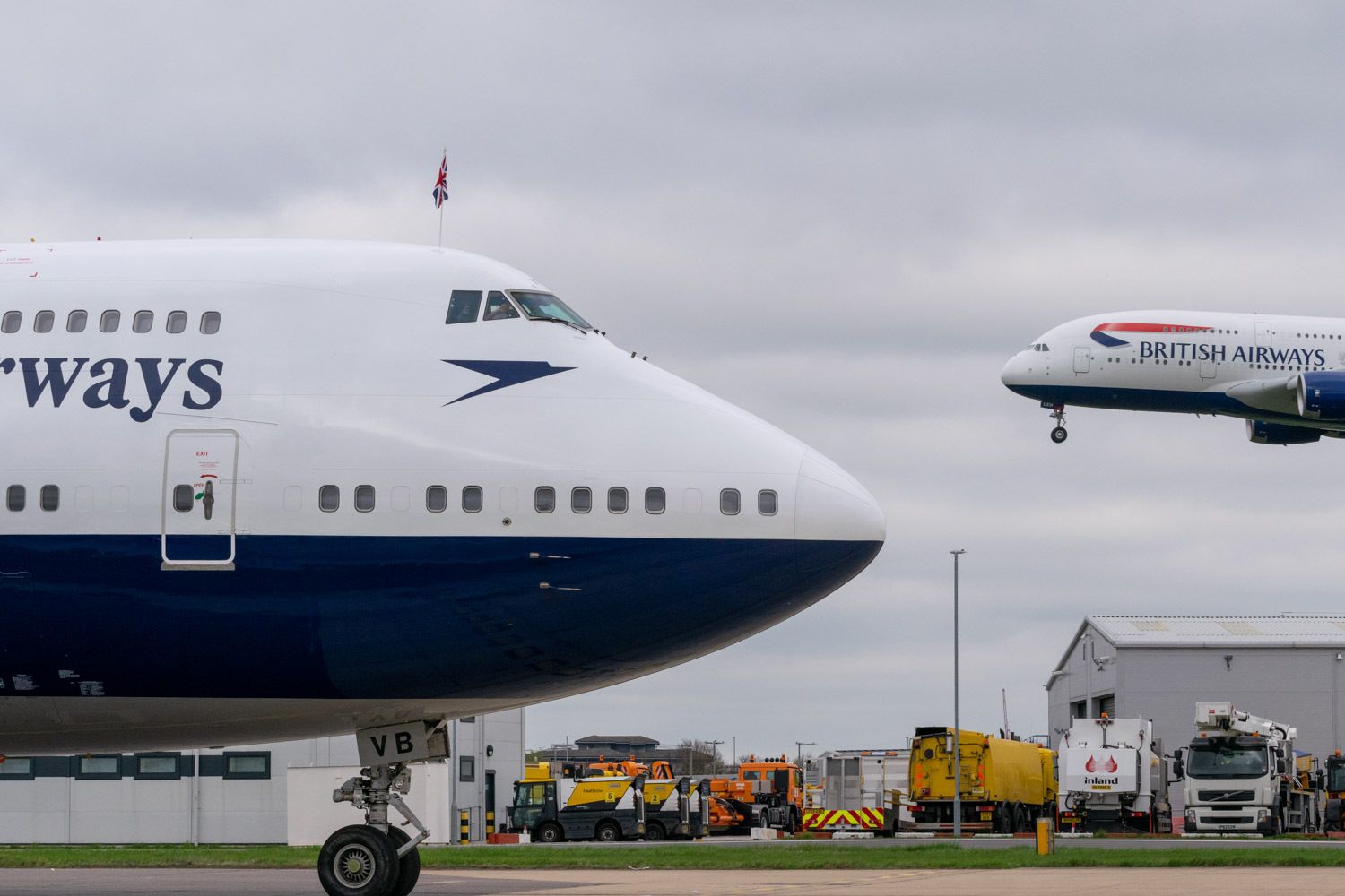 British Airways Boeing 747 taxiing with a British Airways A380 landing in the background.